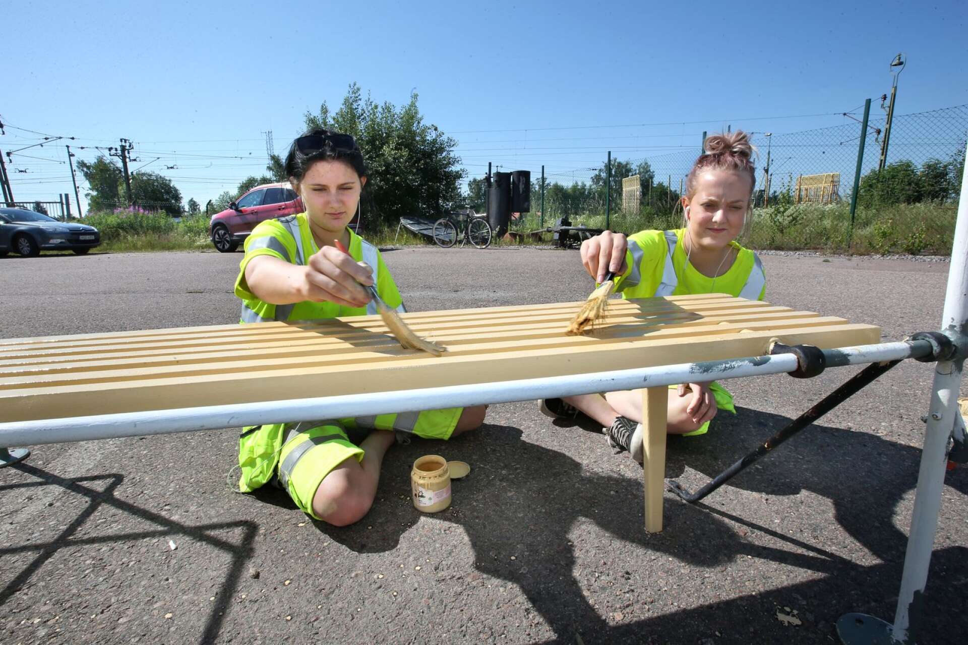Det var varmt i solen för Emilia Johansson och Natalie Johansson som sommarjobbar med att målar bänkar till Freja.