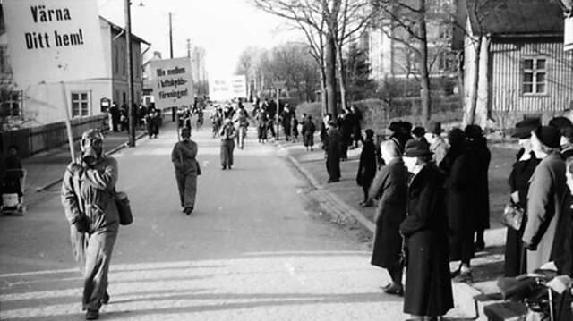 Luftskyddsföreningen demonstrerar 1940 på Tingsgatan i Säffle  under parollerna ”Värna ditt hem” och ”Bliv medlem i Luftskyddsföreningen”