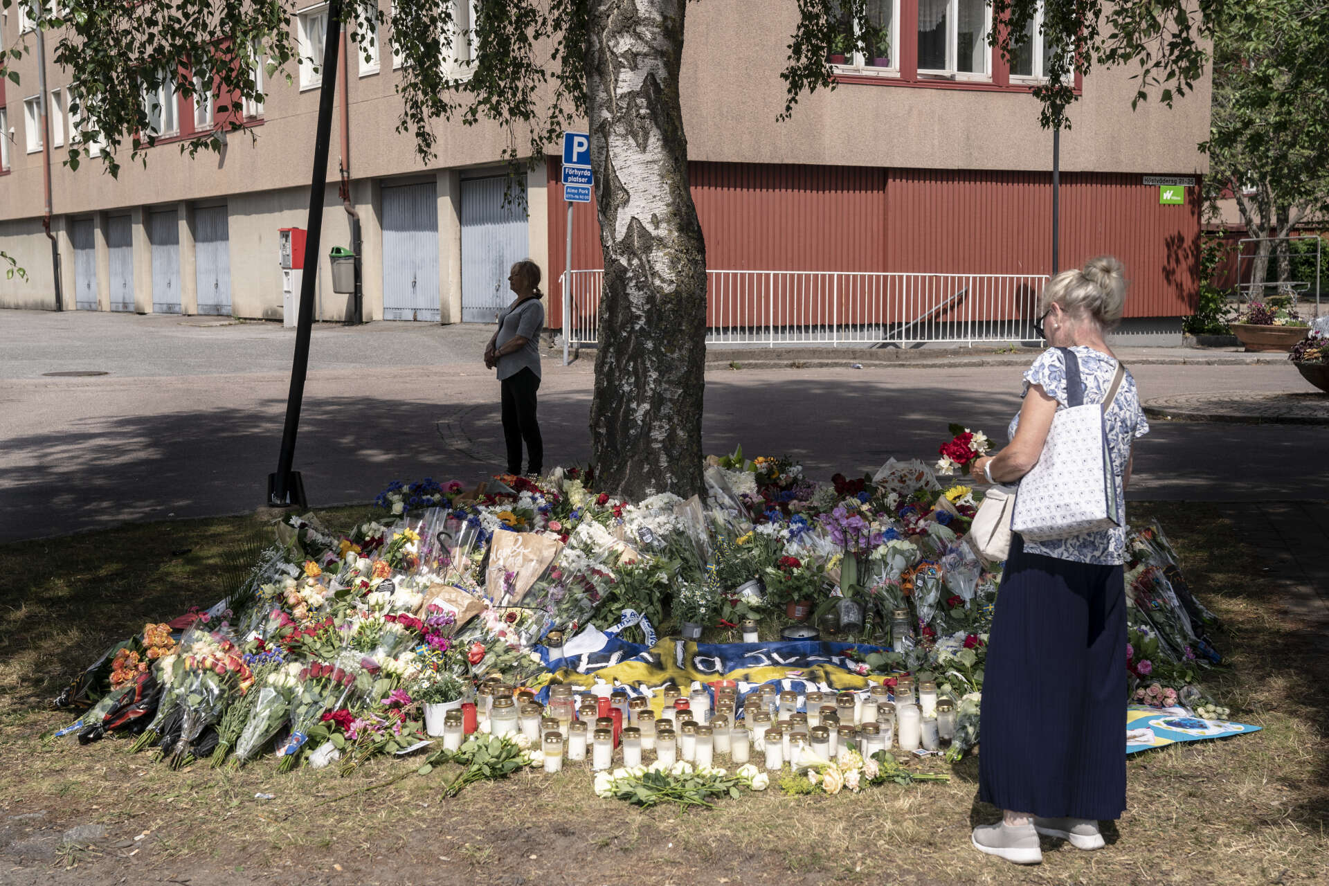 Blomsterhavet växer vid minnesplatsen där en polis sköts till döds på Biskopsgården i Göteborg.