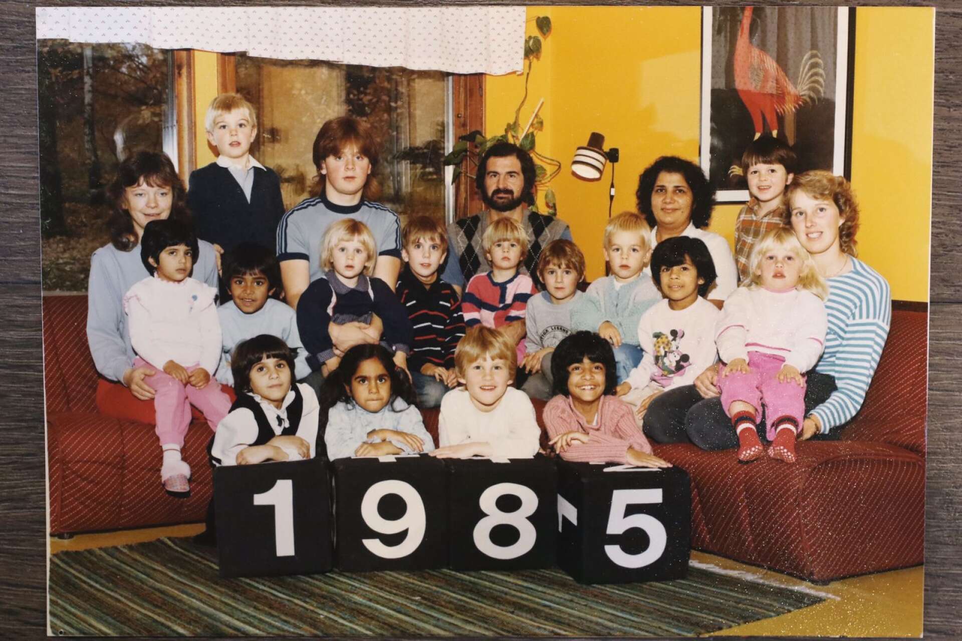 En liten Anni sitter som treåring 1985 i knäet på förskolefröken.