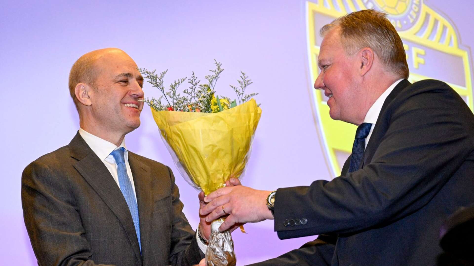 Fredrik Reinfeldt är vald till ny ordförande i Svenska fotbollförbundet och får blommor av avgående Karl-Erik Nilsson .