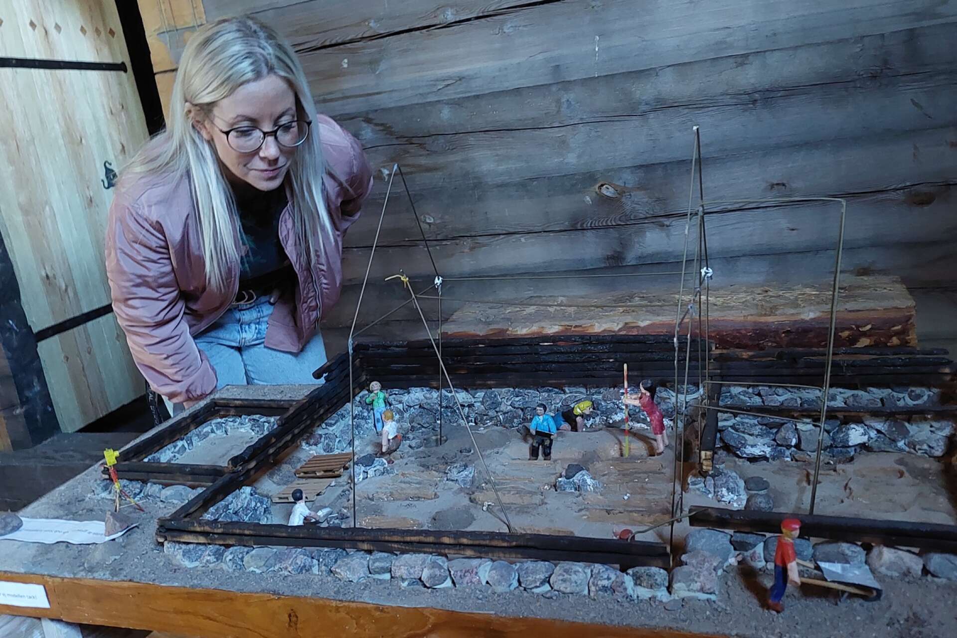 Viktoria Sjöstedt begrundar en modell som visar arkeologer i arbete. 