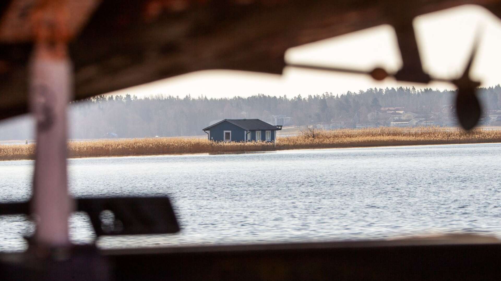 Efter stormen under torsdagen i förra veckan dök den upp i vassen vid Röskär. Och där står den mystiska husbåten fortfarande kvar.