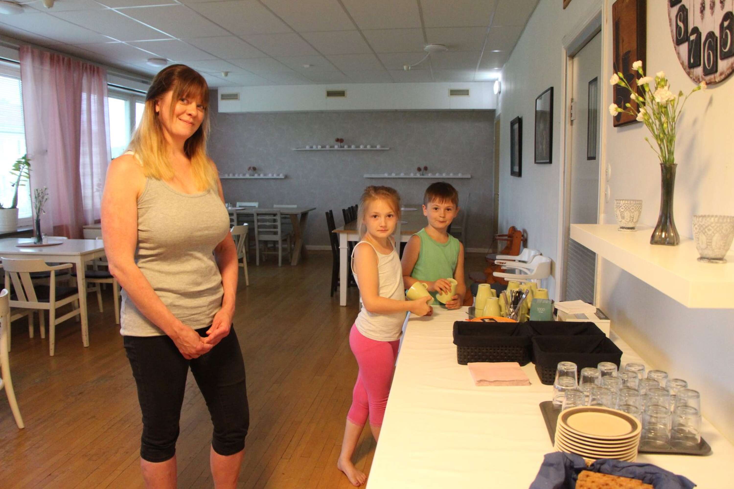 Elina, 9 och Pontus, 7, hjälper Annika Björklund med att ställa i ordning tio-kaffe.