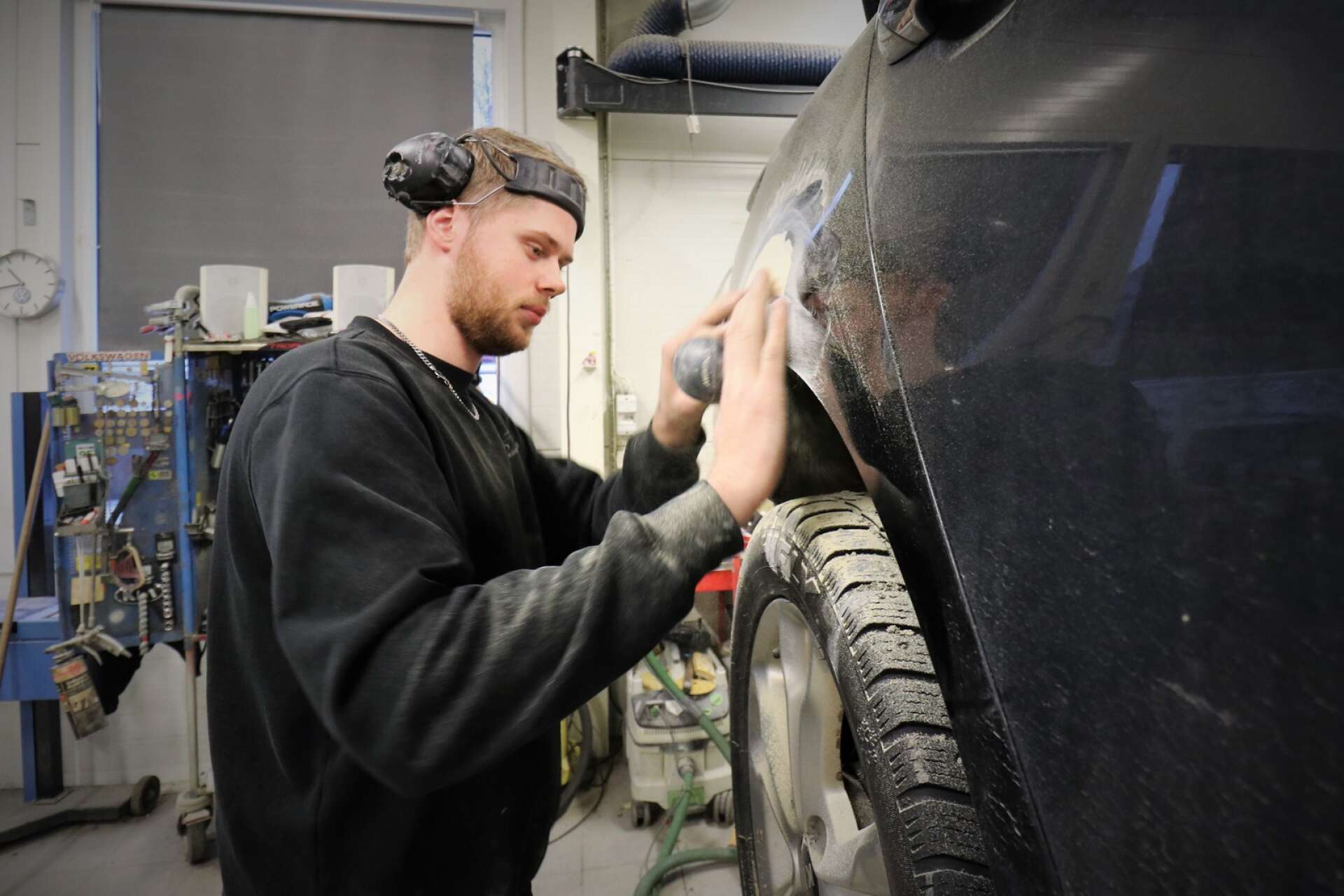 Daniel Persson, som jobbar i skadeverkstaden på Axelssons Motor, är i färd med att reparera en karosskada. 