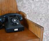Telefonen som stod i det gamla huset har fått sin plats på en byrå.