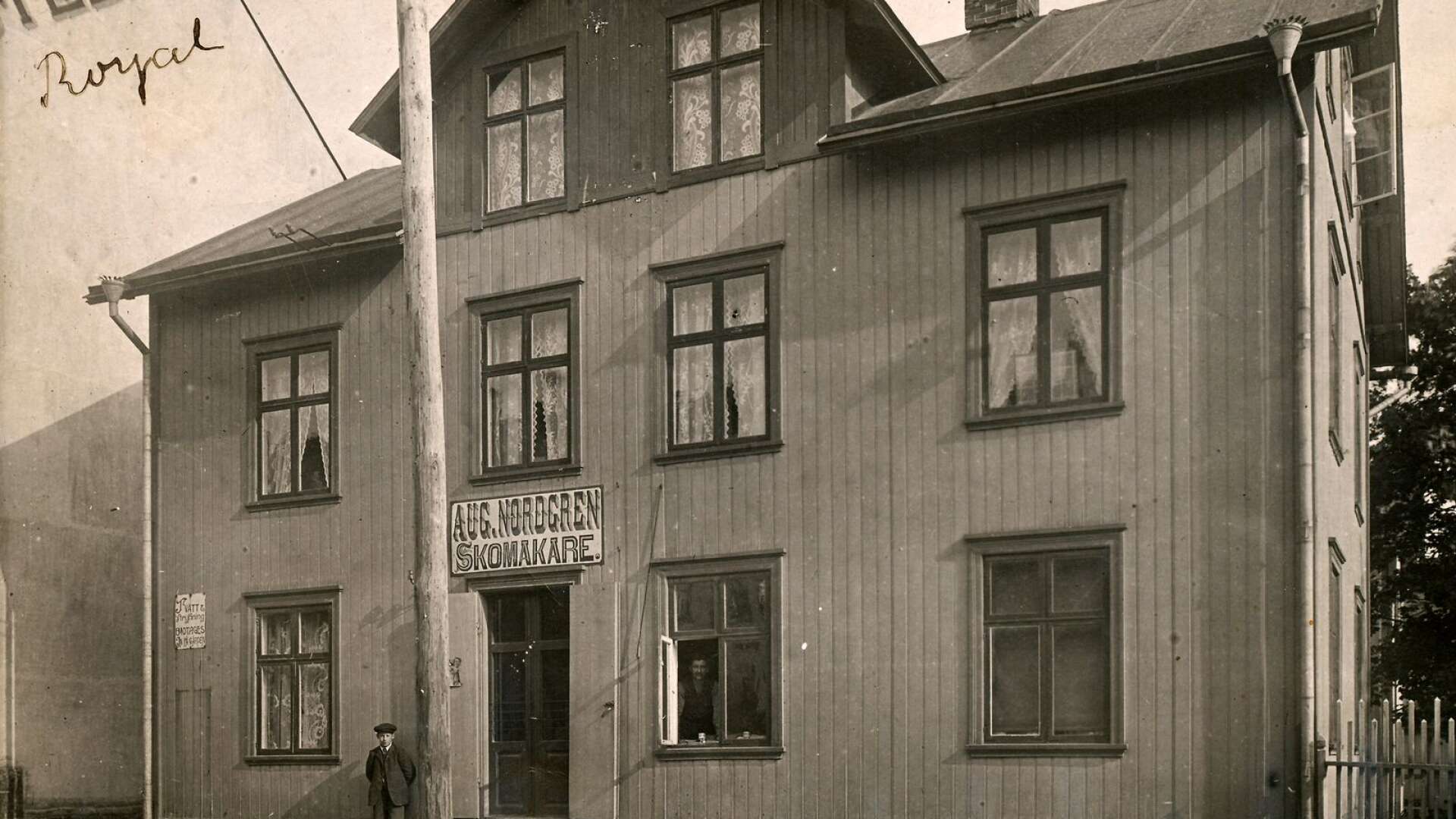 1912 skickade skomakare August Nordgren ett vykort till fröken Balder i Bäckefors. Han valde ett motiv från Kungsgatan 15, en bild där han själv skymtar i fönsteröppningen. Huset finns fortfarande kvar, om än med ett helt nytt utseende.