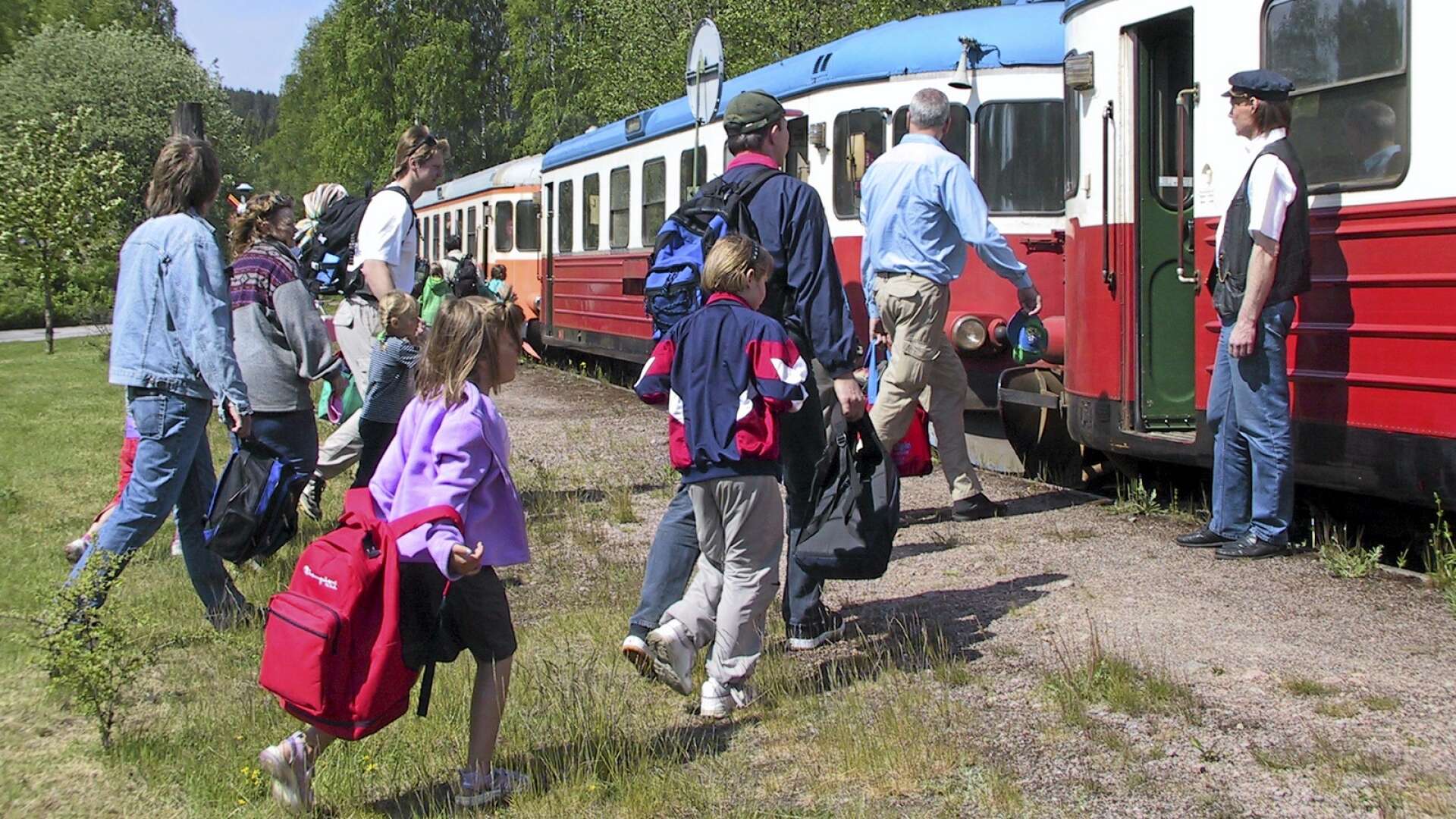 Turister stiger på DVVJ:s sommartåg i Långbron, Dals Långed.