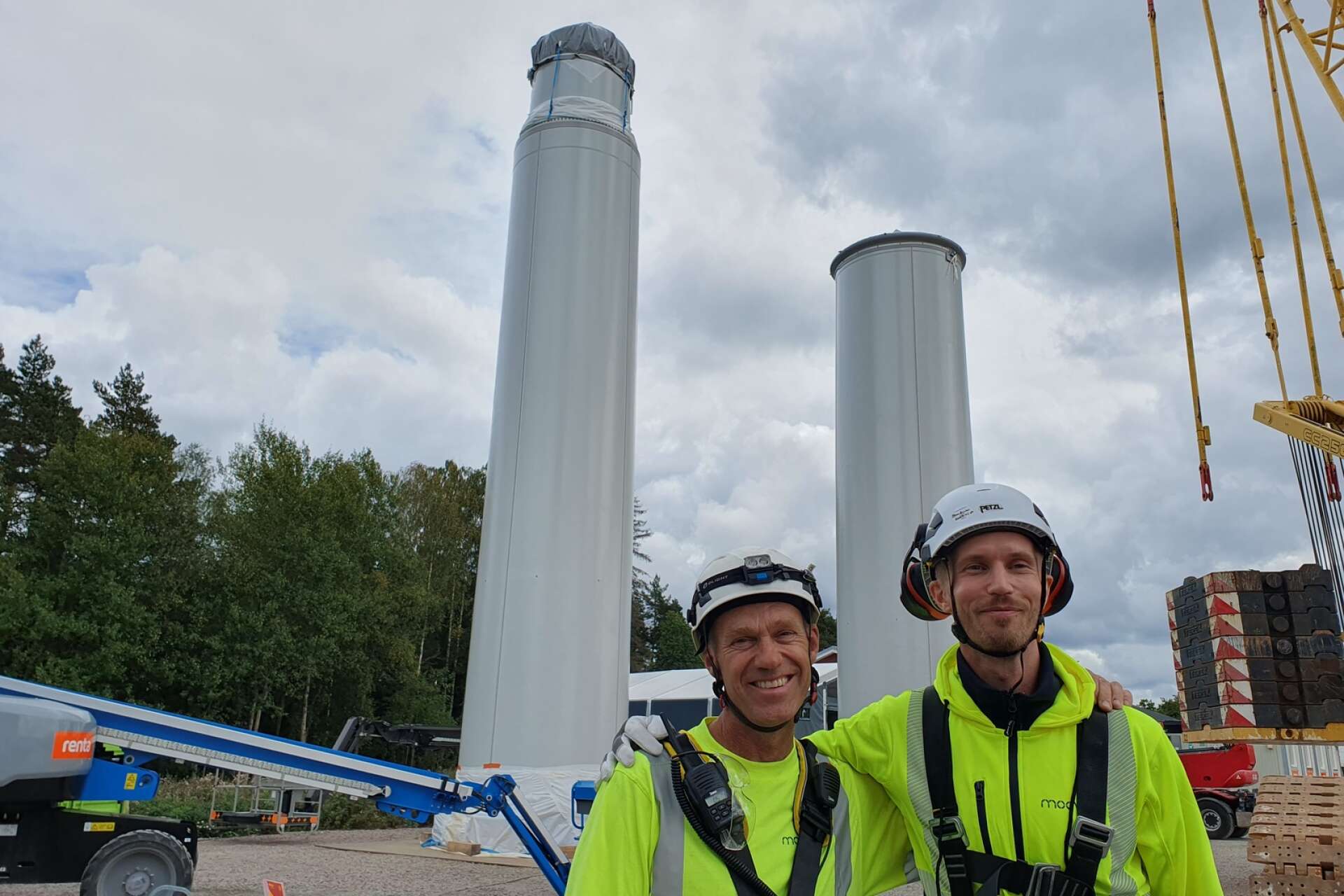 David Olivegren, grundare och upphovsman och Otto Lundman, grundare och verkställande direktör, framför de två sista delarna som ska monteras på vindkraftstornet som byggs i trä utanför Skara.