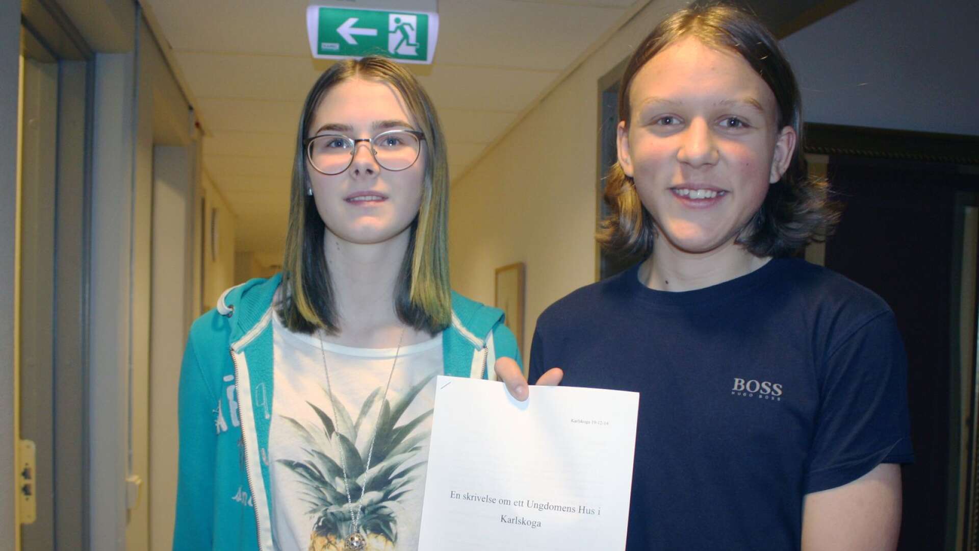 Ungdomsfullmäktiges Ylva Johansson och Adam Granquist håller upp den rapport som sammanställts kring ett Ungdomens hus.