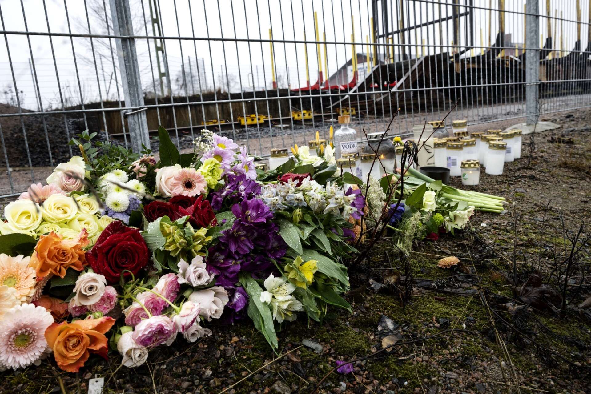 Blommor och ljus vid minnesplatsen för mannen som omkom.