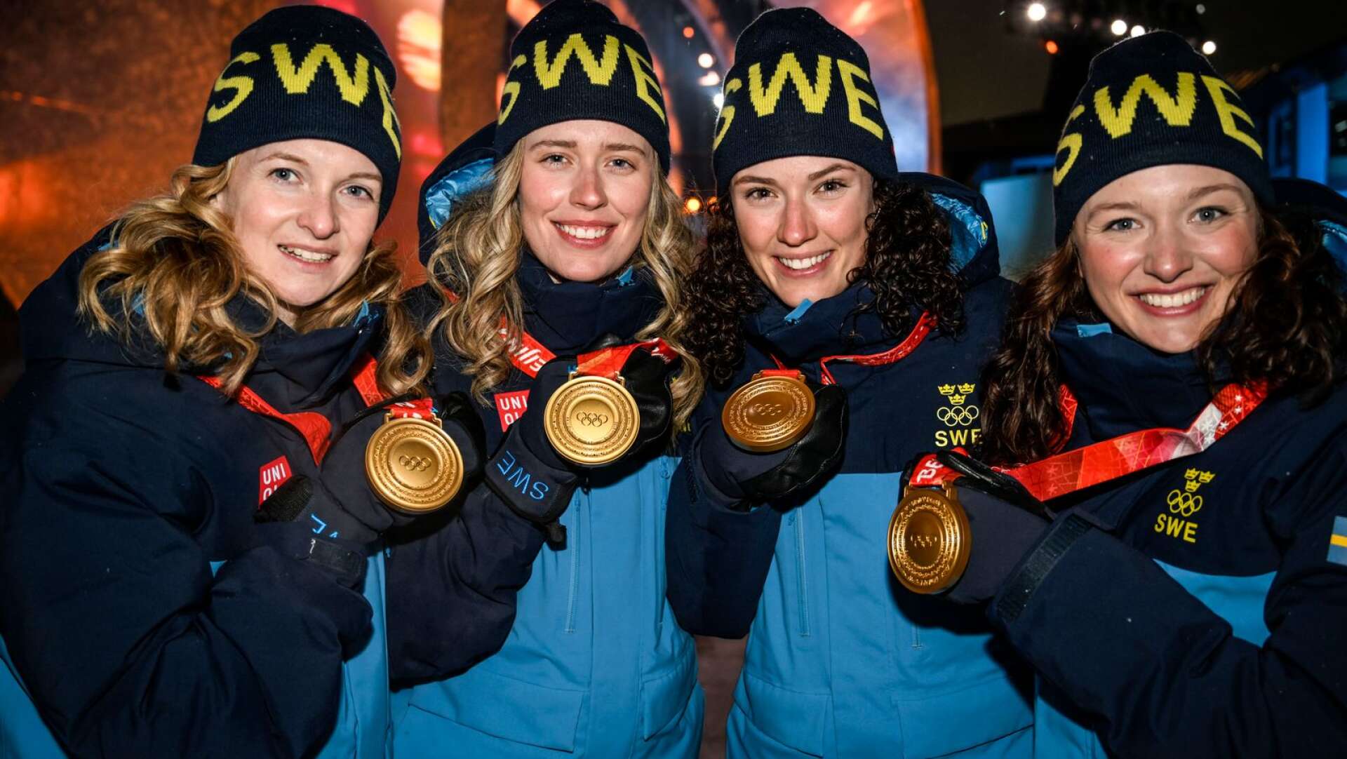 Mona Brorsson tillsammans med Elvira och Hanna Öberg samt Linn Persson efter OS-guldet i Peking förra vintern.