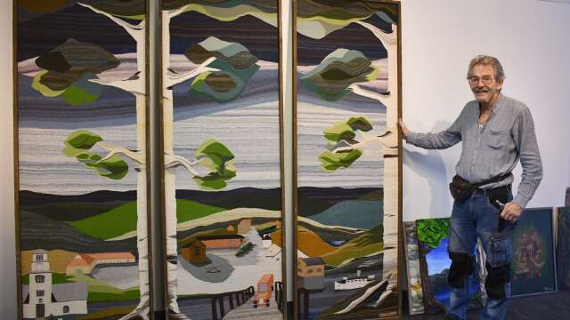 PeO Gustafsson med en stor vävd triptyk som visas på Galleri Himmel och hav i Sunne.