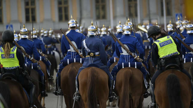 Den beridna högvakten passerar med sina spetsiga paradhjälmar och uniformer från 1800-talet, på Strömgatan på sin väg mot Stockholms slott. Arkivbild.