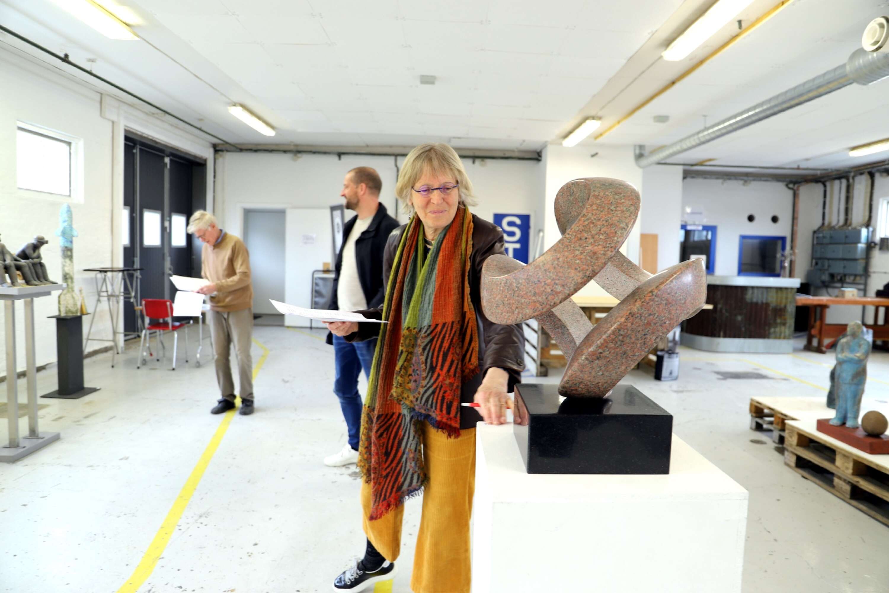 Elsa Hallbäck från Värmlands konstförening gillar att det är mycket skulpturer på den värmländska vårsalongen. Här står hon vid Arvikakonstnären Ulf Johnsons Open globe i röd granit och diabas, som trots sin tyngd ser ut att utmana själva tyngdlagen.
