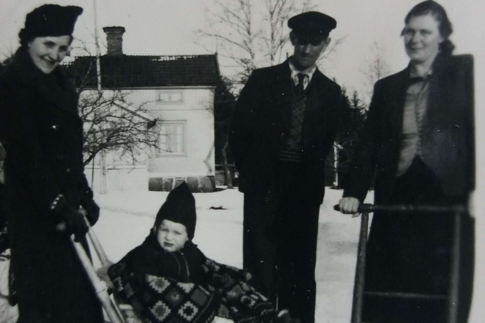 En tvåårig Gunnar Edström på sparken träffar tillsammans med sin mamma Hilmer och Lilly Eklund framför deras lilla hus vid Rönneberg.