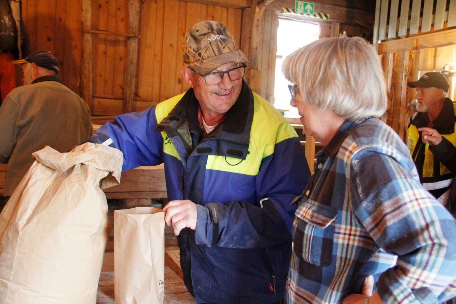 Johnny Svensson väger upp mjöl i samspråk med Ellionor Moberg.
