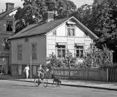 Vid Västra Storgatan såg man 1951 bland annat detta hus. Det låg snett mitt emot korsningen med Hamngatan och i huset fanns Systrarna Ödqvists hembageri. Huset som skymtar till vänster finns fortfarande kvar. 