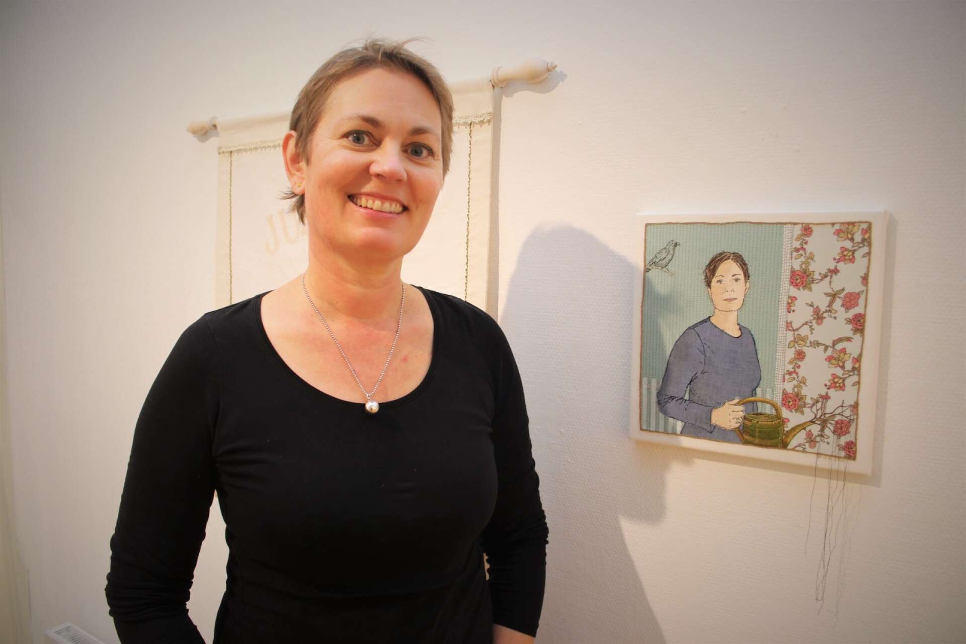 Erika Broman har med sig flera bildbroderier till utställningen. Här framför ett broderat självporträtt. 