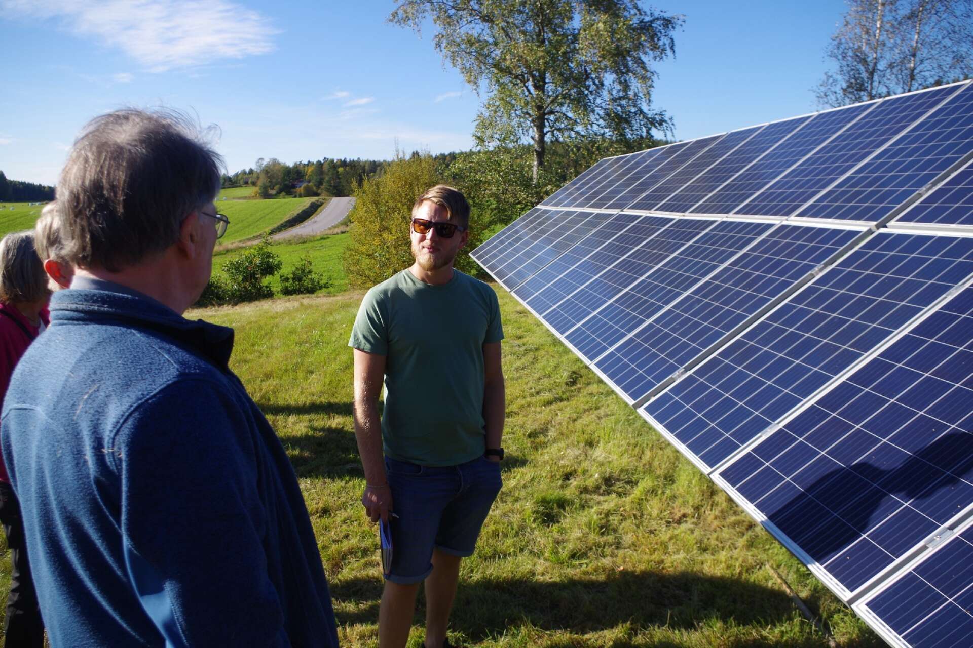 Johan Lindh, till höger) hade mycket att fråga om. Han står framför några av de 70 kvadratmeter solcellspaneler som finns monterade i Brosäter.