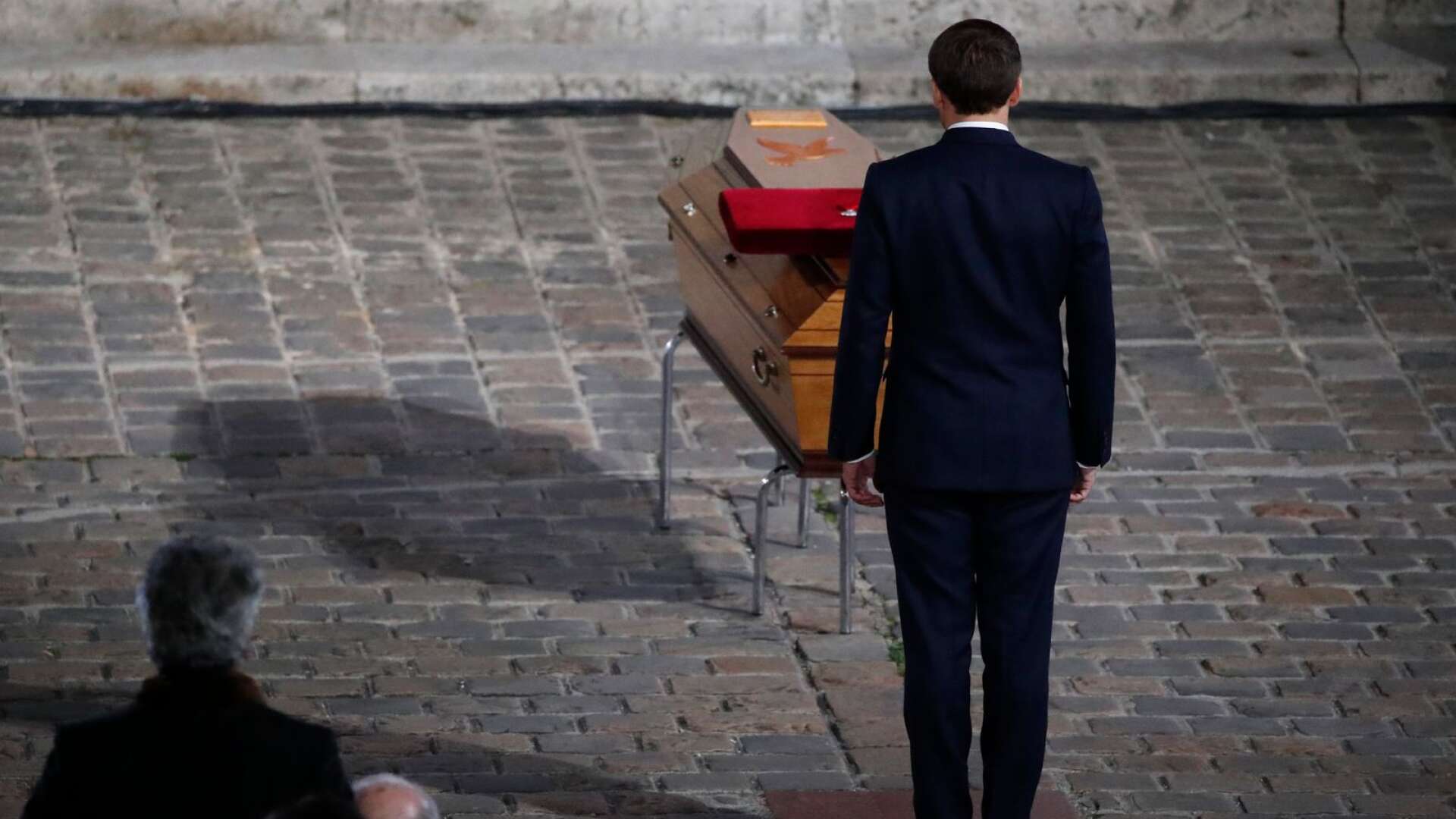 Den franske presidenten Emmanuel Macron hedrar kistan med den mördade läraren Samuel Paty under en minnesceremoni i onsdags. Foto Francois Mori/Pool/AP