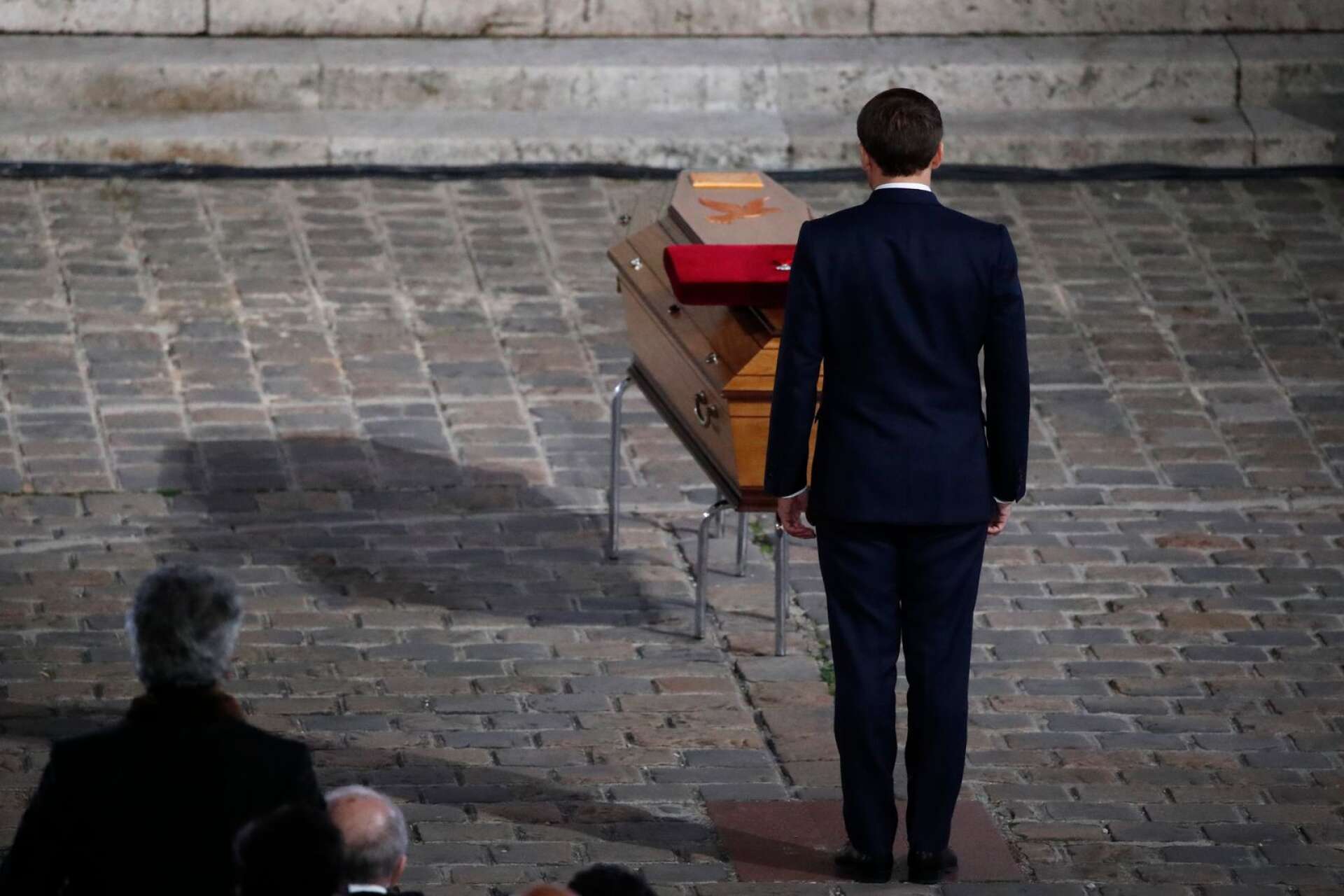 Den franske presidenten Emmanuel Macron hedrar kistan med den mördade läraren Samuel Paty under en minnesceremoni i onsdags. Foto Francois Mori/Pool/AP