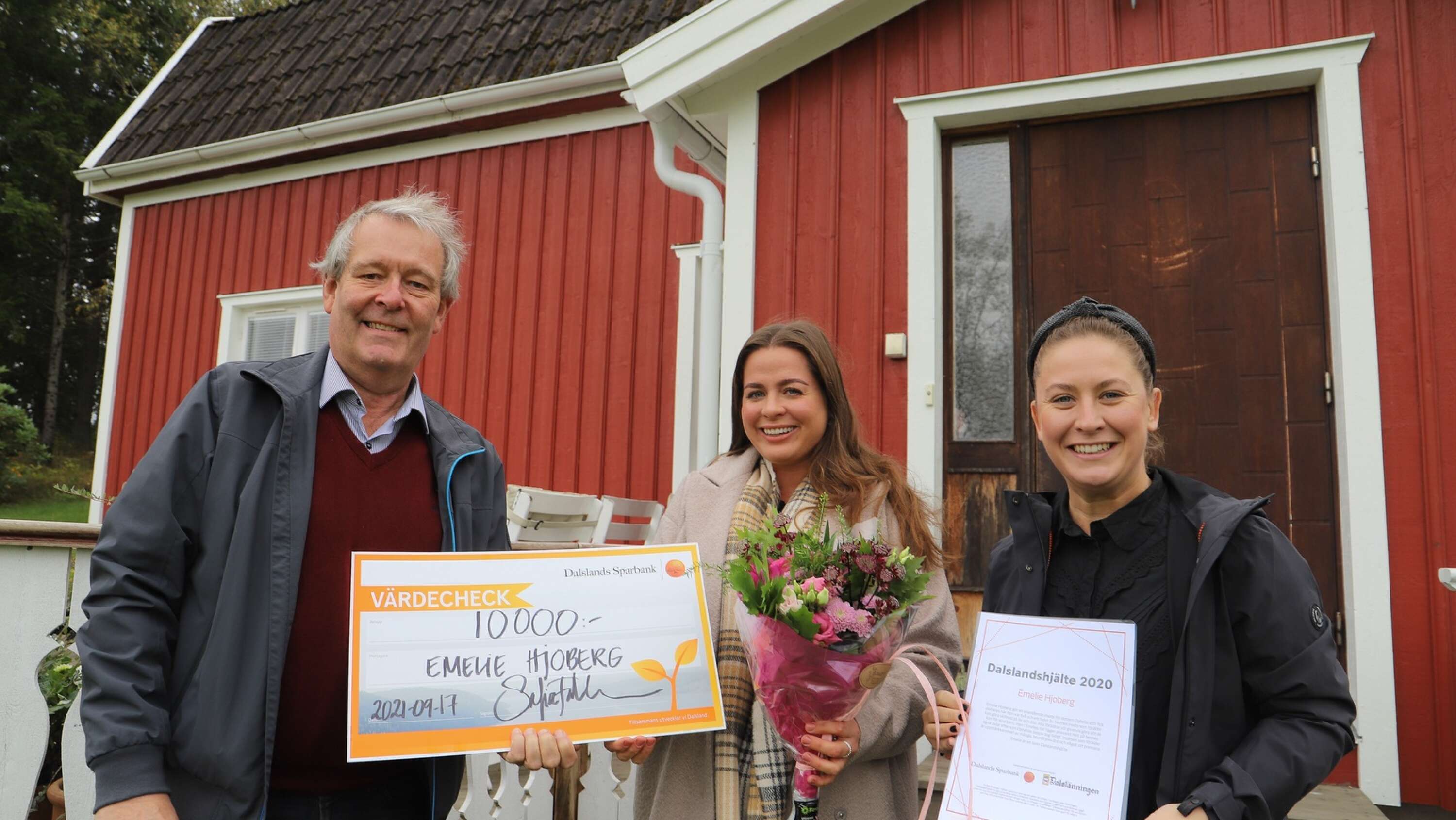 Som Dalslandshjälte 2020 fick Emelie Hjoberg, prischeck, diplom och blommor, när hon uppvaktades av Thomas Wallin, Dalslänningen, och Sofia Falkman, Dalslands Sparbank.