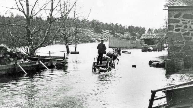 Detta är en klassisk bild från vårfloden 1904. Ett ekipage med häst och vagn passerar genom vattnet som når upp till Stenmagasinet.