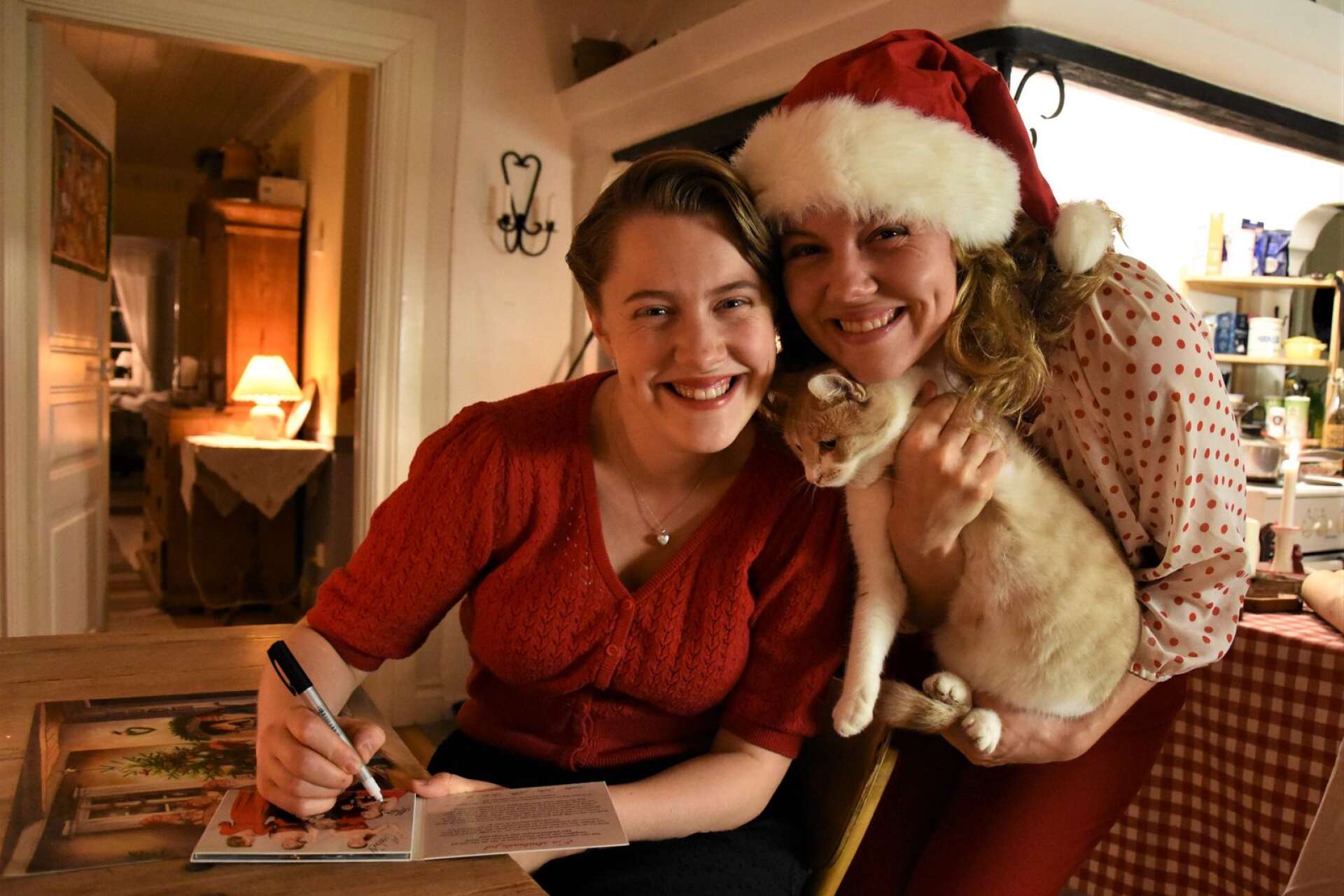 Maria och Josefin Hebbe signerar julskivor vid köksbordet.