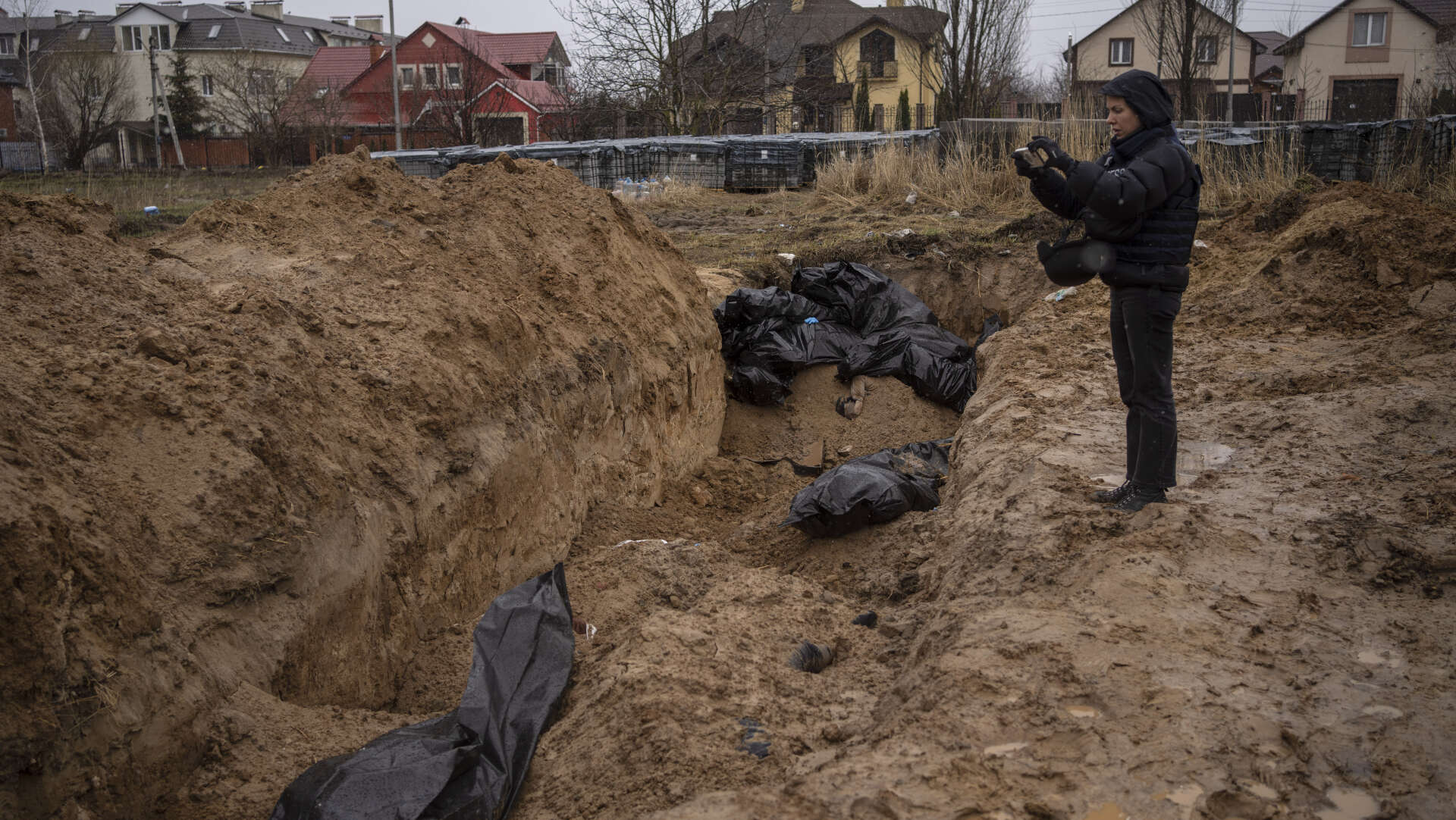 En journalist tar på söndagen den 3 april en bild på en massgrav i Butja, utanför Kiev.