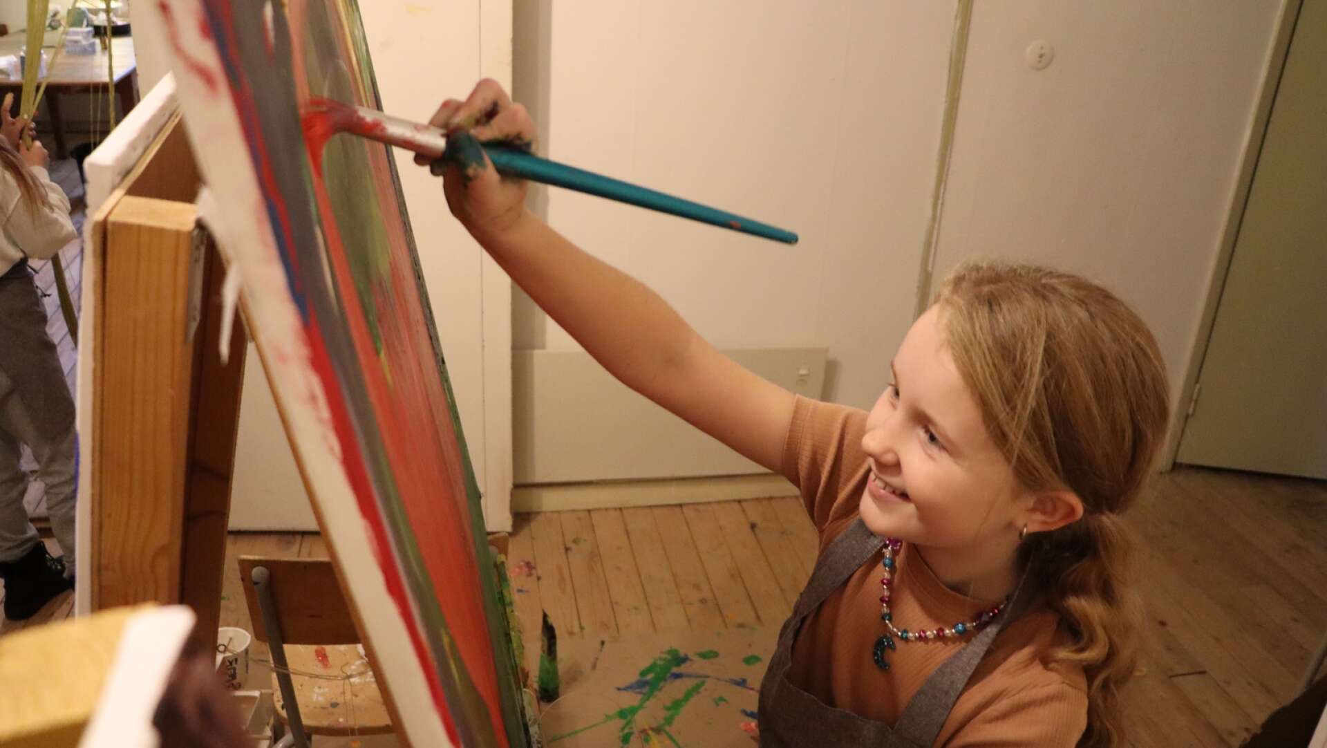 Lily Franzén, 9 år, passade på att dra några penseldrag på den gemensamma tavlan alla deltagare får måla på tillsammans. 