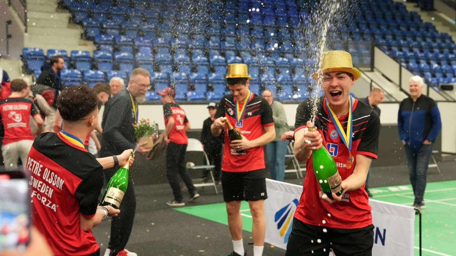 Ludvig Petre Olsson firar med att spruta champagne. I bakgrunden syns pappa Jesper Olsson.