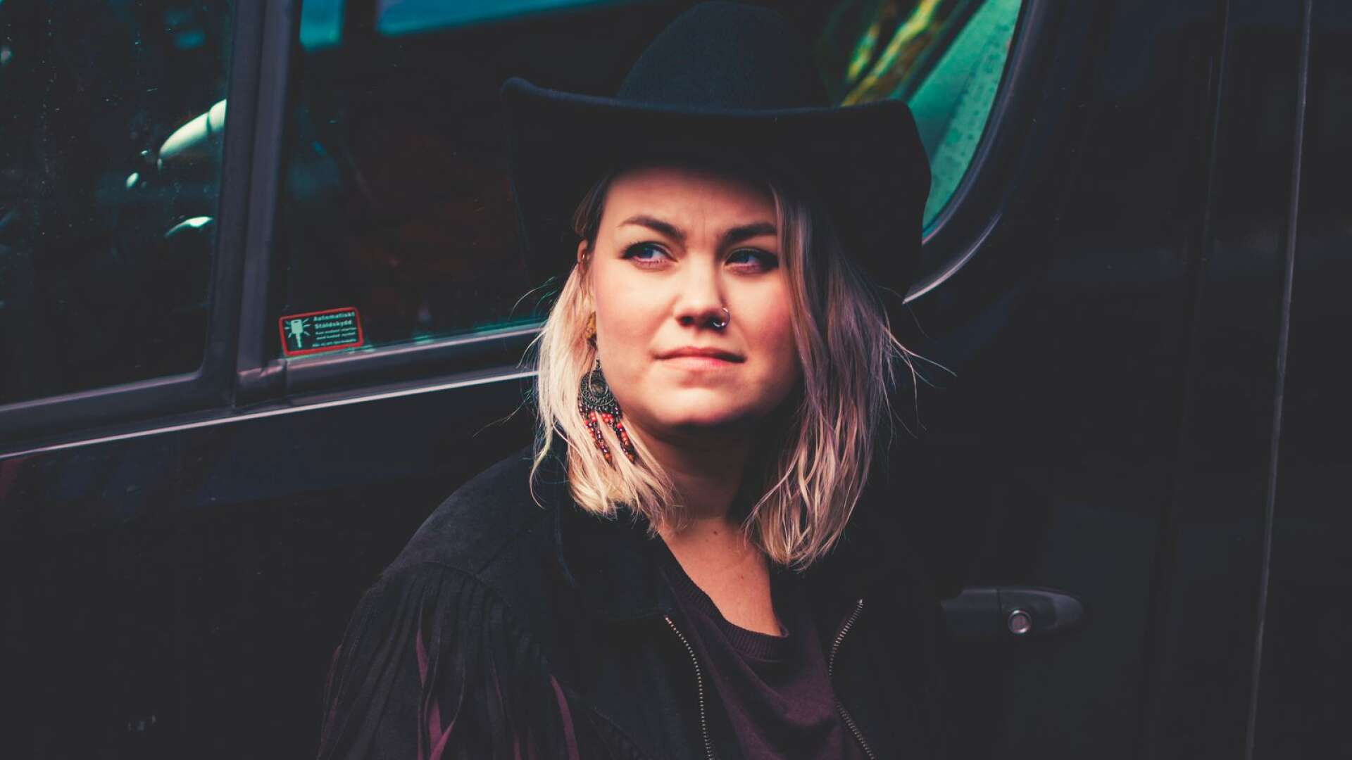 Den värmländska countryartisten Erika Jonsson framför förarhytten på lastbilen. 