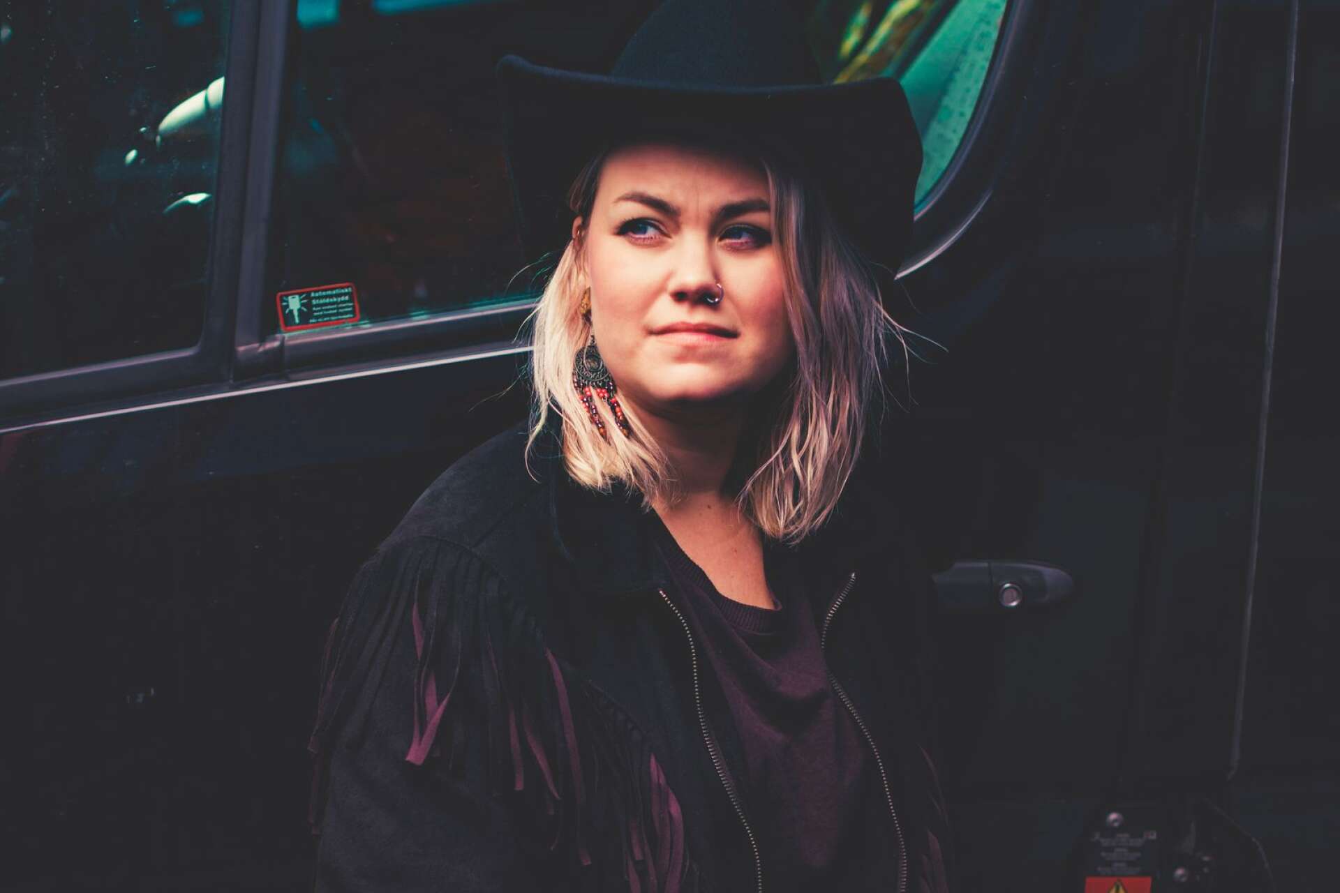 Den värmländska countryartisten Erika Jonsson framför förarhytten på lastbilen. 