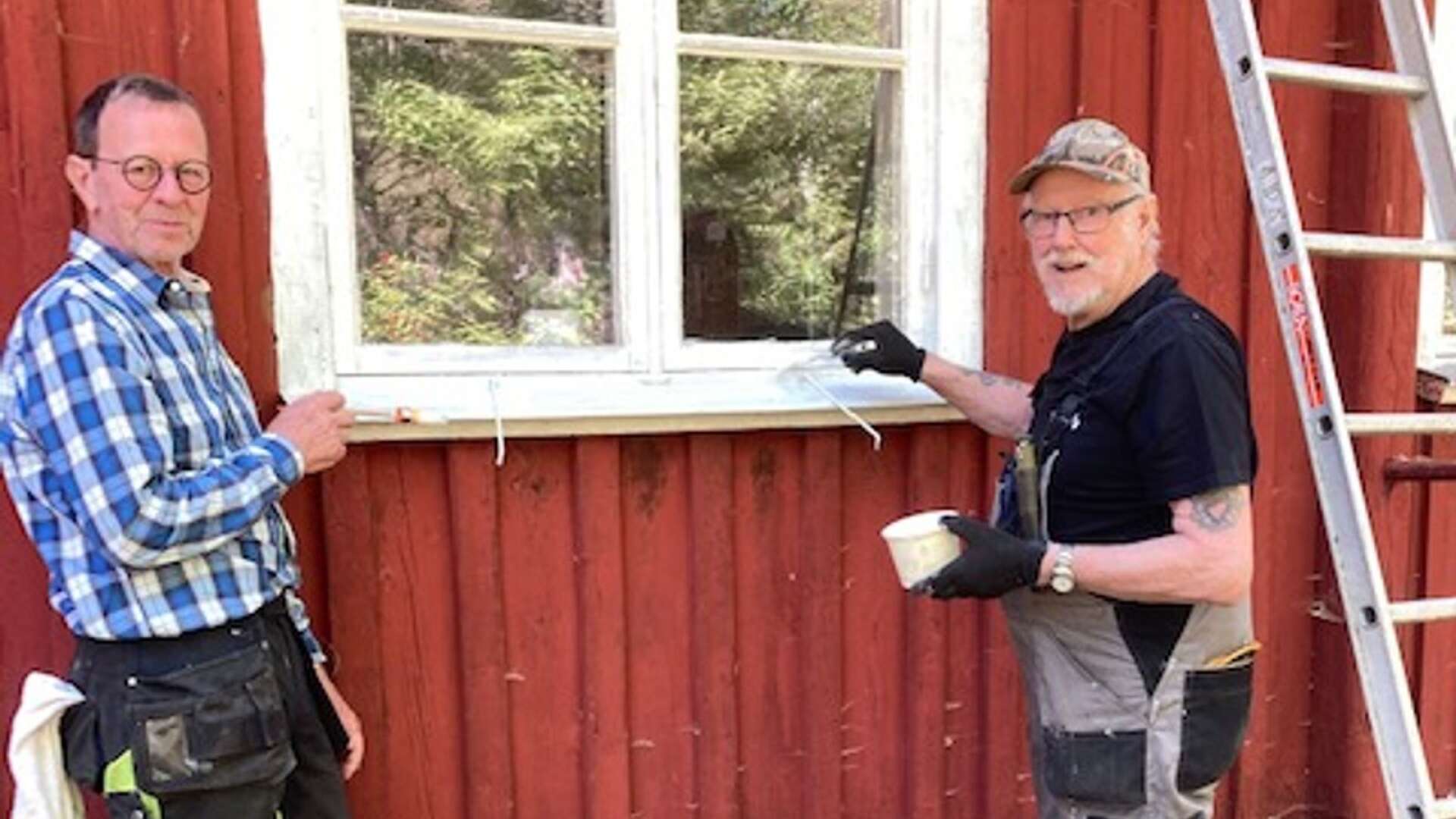 Bengt-Åke Lövgren och Rolf Andersson kittar och målar fönstren på Årbols skolmuseum.