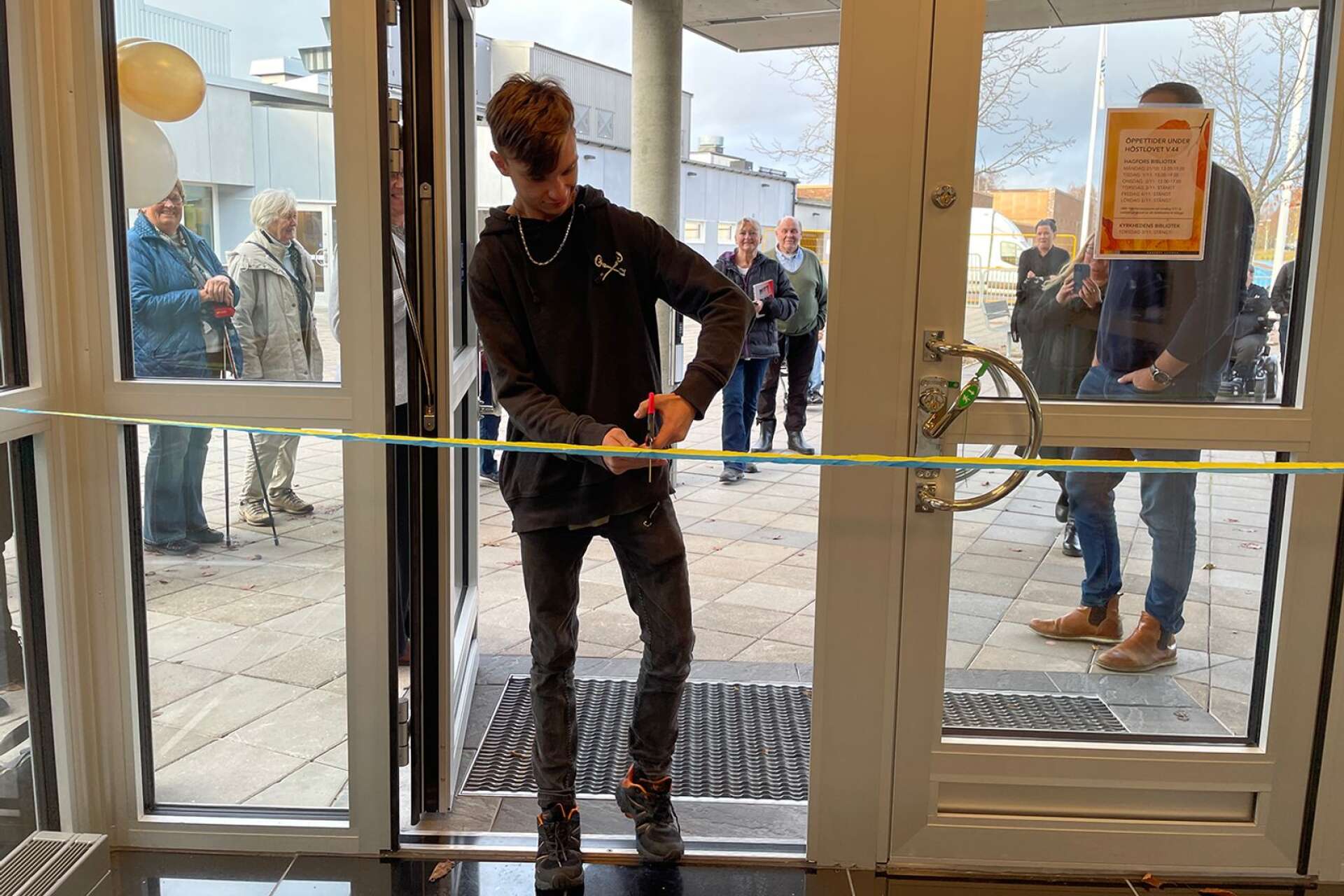 Den flitige biblioteksbesökaren Elias Nilsson klippte bandet när den nya ingången till biblioteket invigdes.