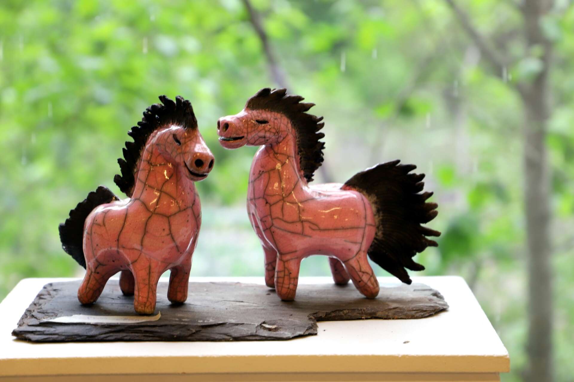 Rosa hästar i raku-keramik av Mia Jansson.