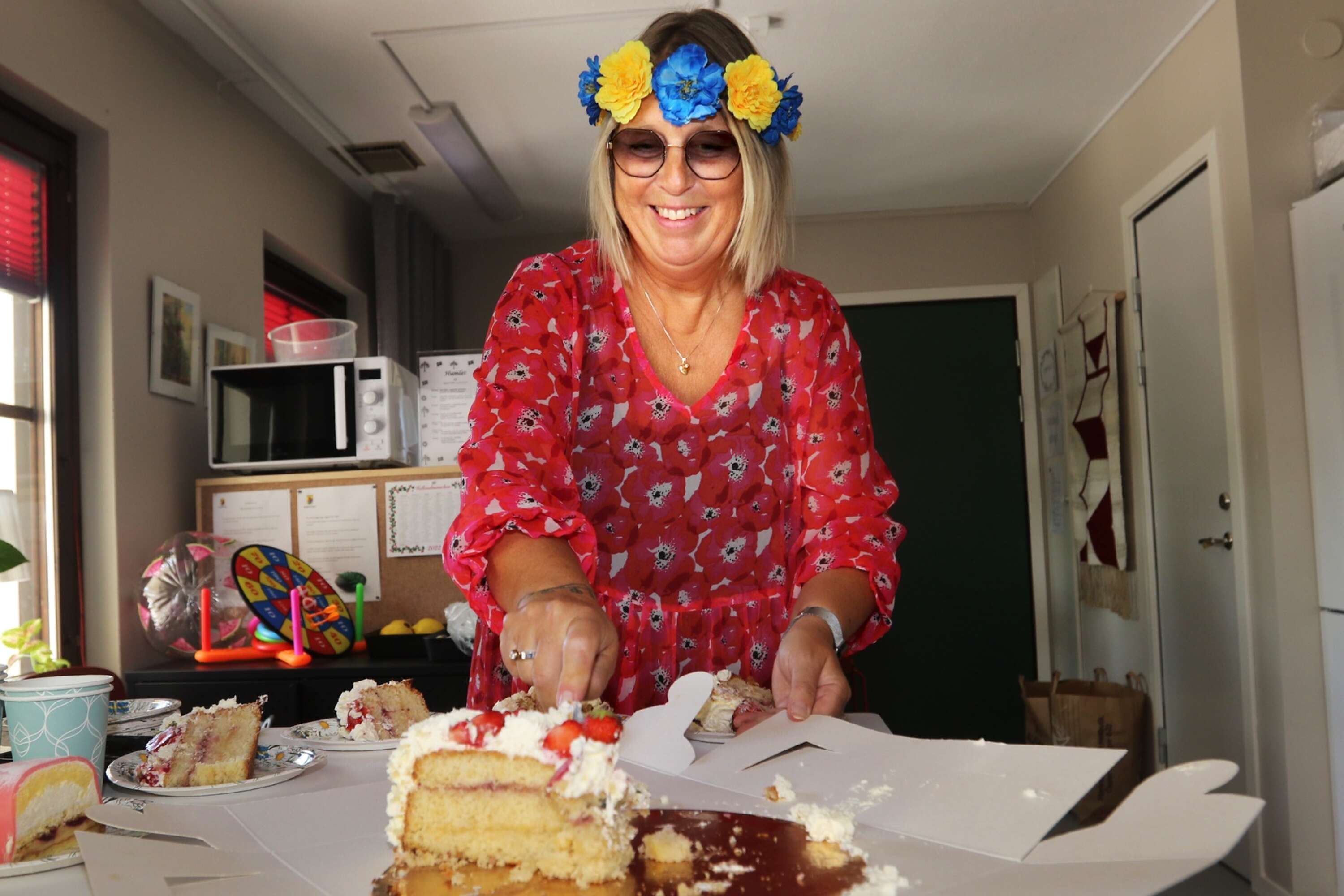 Annelie Blomberg, anhörigsamordnare på Mariestads kommun, serverade jordgubbstårta till midsommargästerna.