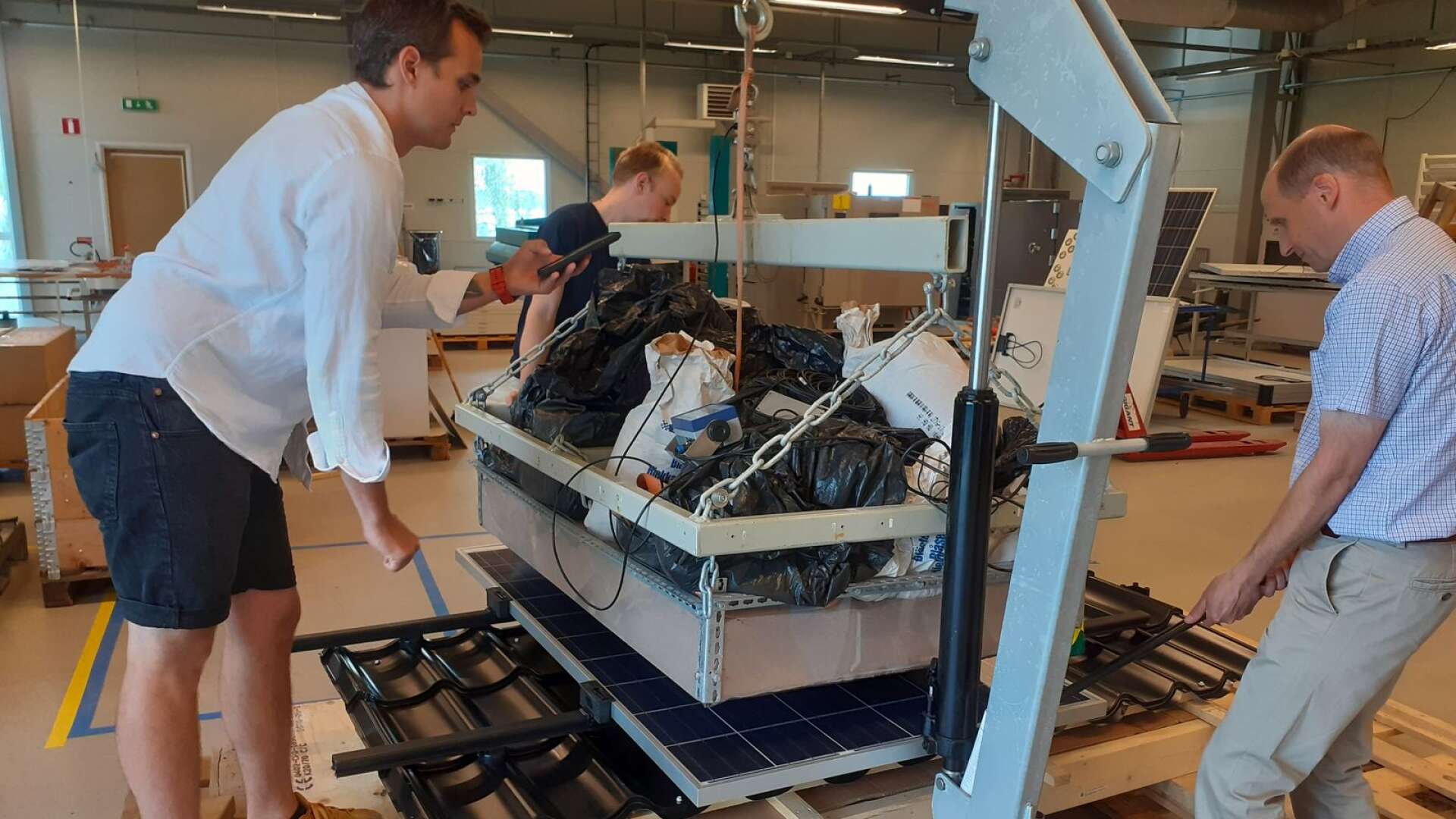 Tekniskt ansvarige Johan Ericson, testingenjör Viktor Tillman och verksamhetschefen Magnus Nilsson utsätter en solpanel för ett tufft test som visar om fästanordningen är säker.