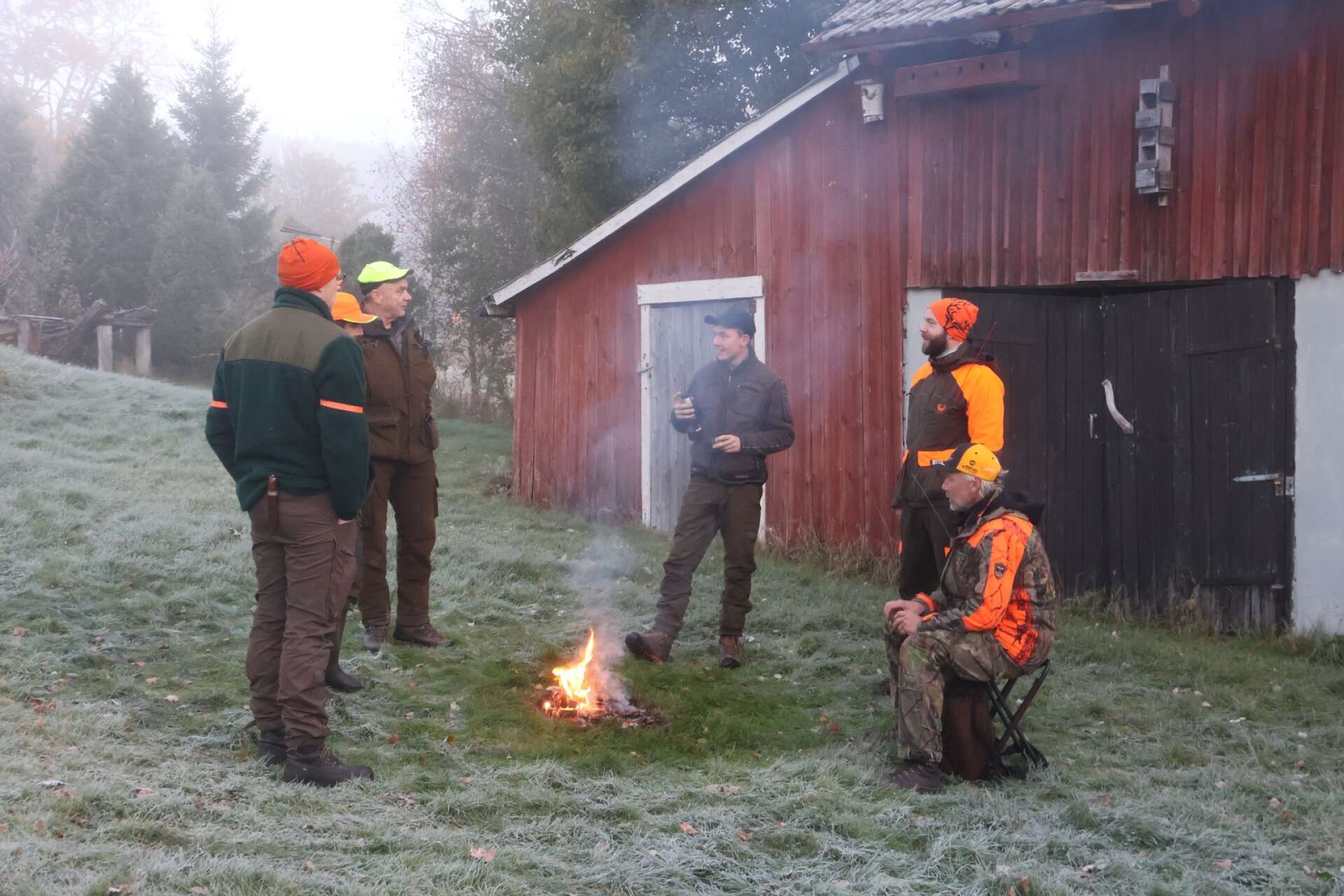 Älgjaktlaget samlas vid brasan i Solvik och jaktledare är Kaj Westerbacka, sittande.