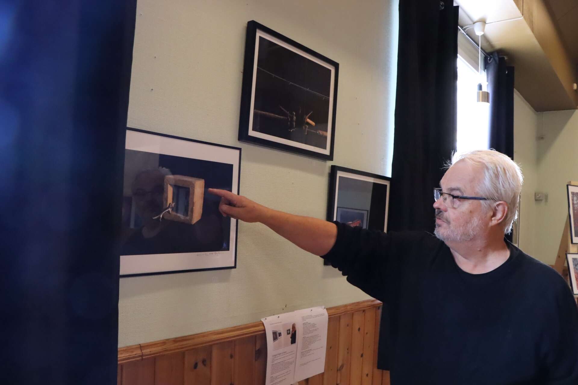 Jörgen Carlsson visar foton på utställningen i Otterbäcken. 
