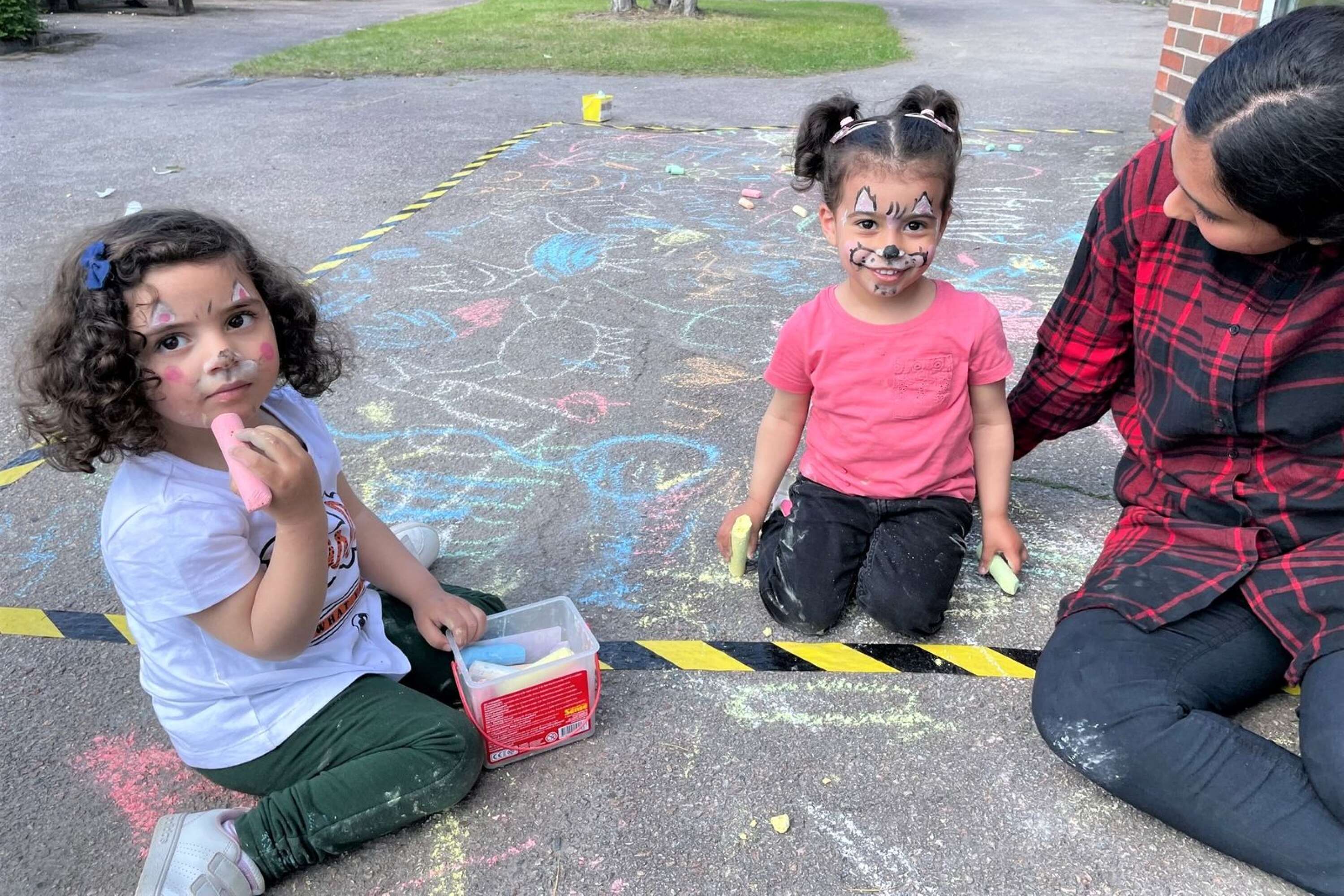 Alma och Leen hade varit på ansiktsmålning, men testade också att måla med gatukritor. Här tillsammans med Shaimaa.