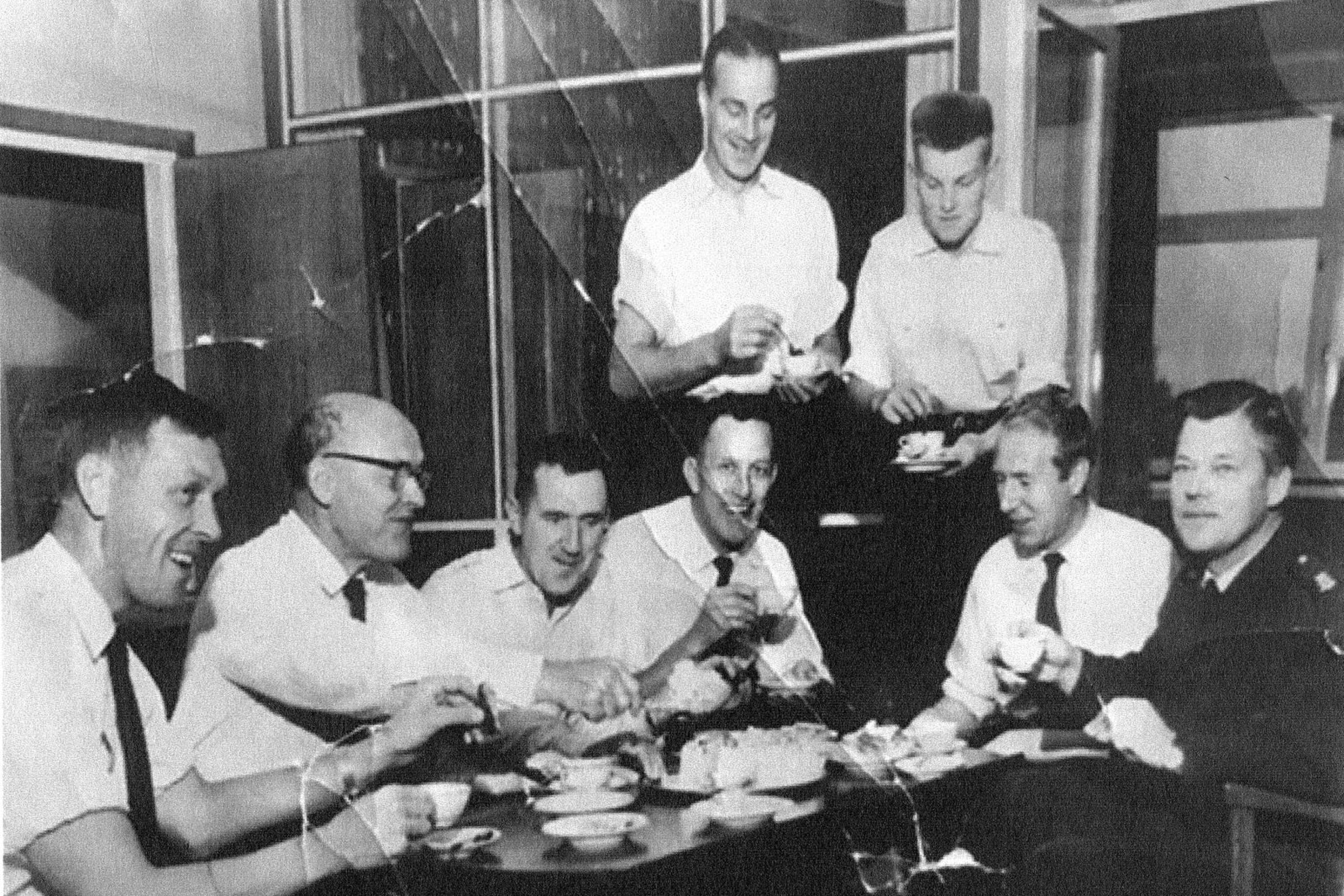 Brandmännen firar med tårta efter att Karlstadspyromanen åkte fast 1959. Sittande från vänster: P.O. Wermelin, Gösta Olsson, okänd, Erik Löved, Bengt Andersson och Gösta Måwe. Stående: Göte Grääs och Sune Almkvist. 