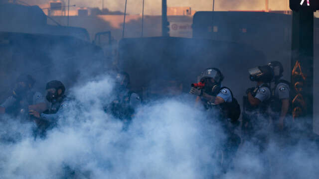 Polisen avfyrar tårgas vid protesterna i Saint Paul i Minnesota på fredagen.