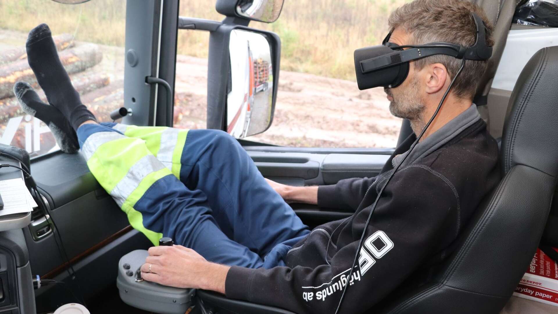 Virtual reality-teknik i lastbilshytten. Mattias Johansson använder VR-glasögon och joystick när han lastar timmer.
