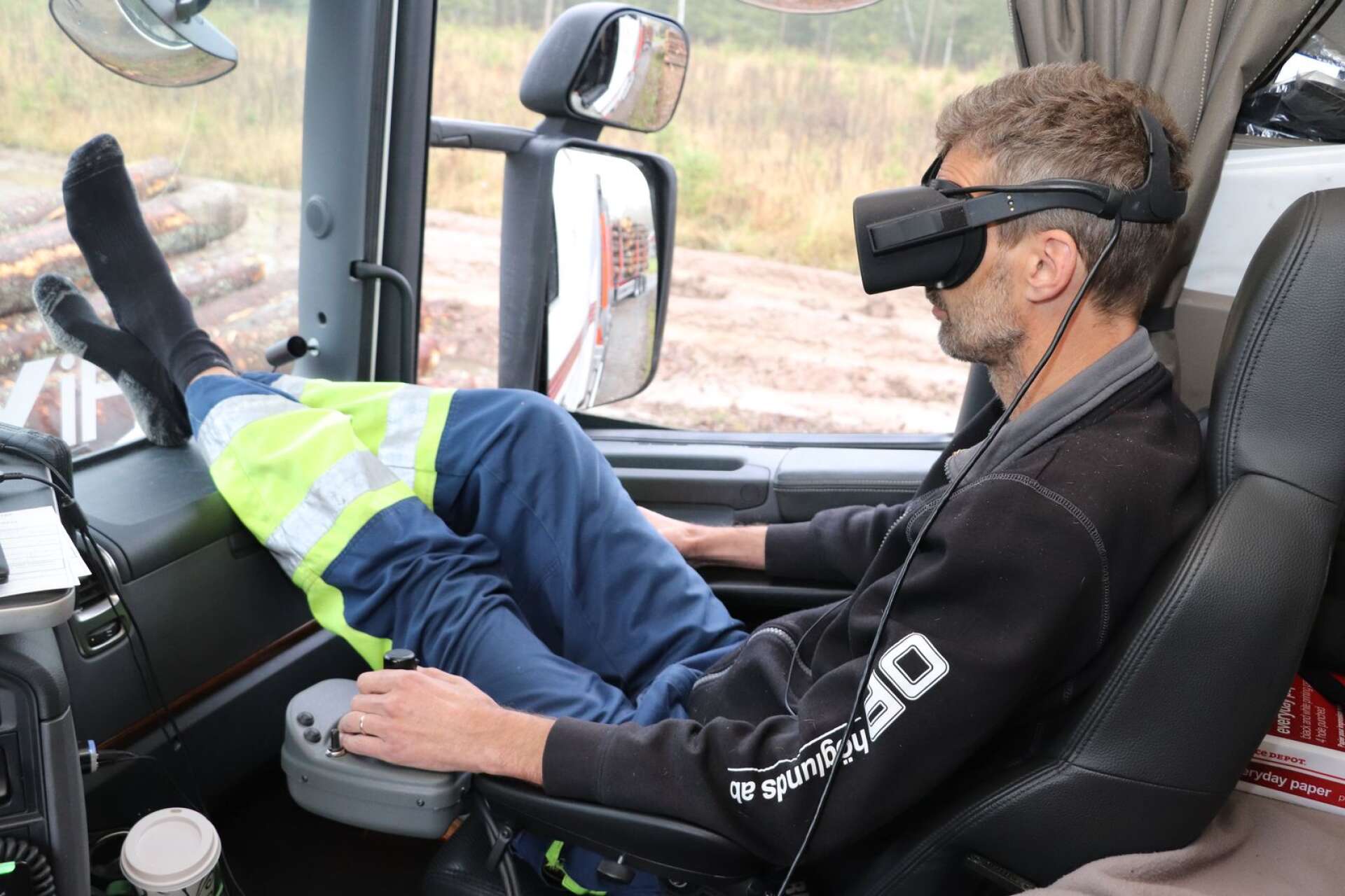 Virtual reality-teknik i lastbilshytten. Mattias Johansson använder VR-glasögon och joystick när han lastar timmer.