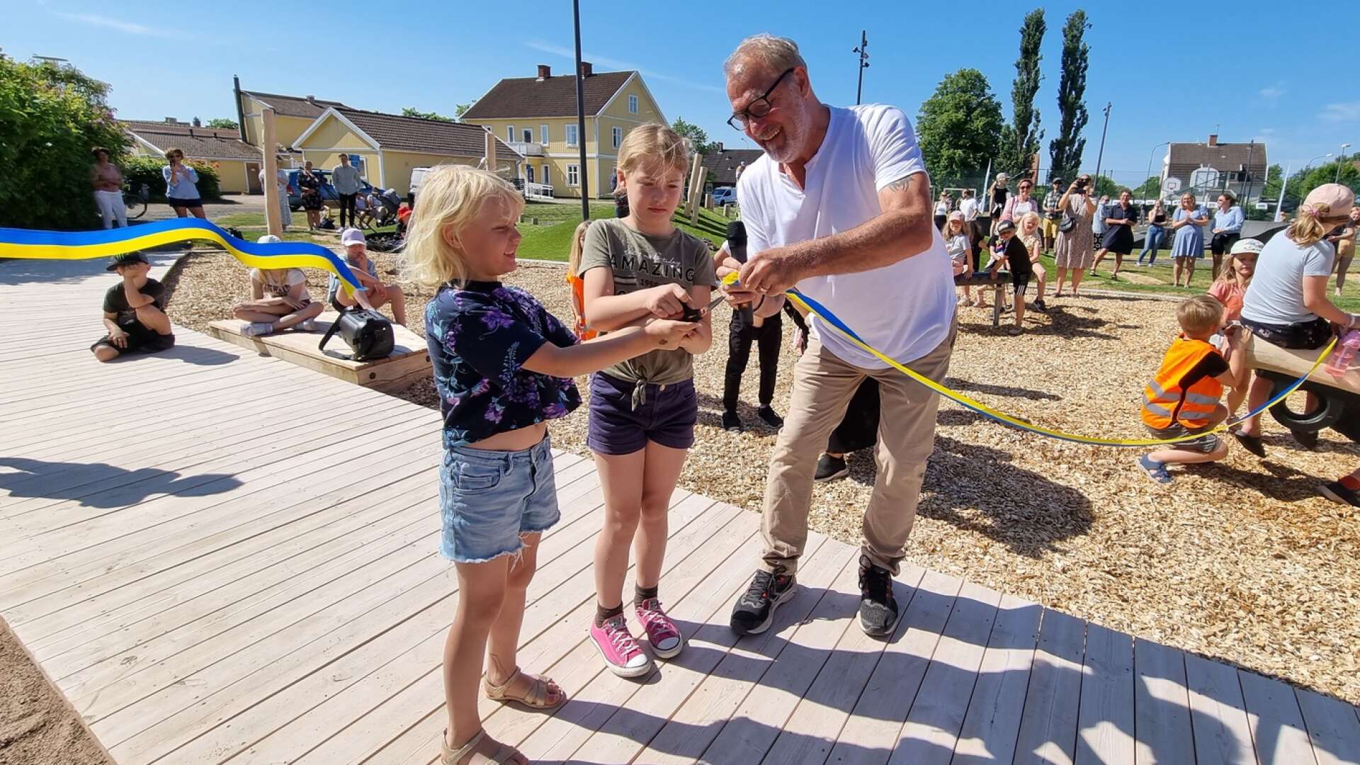 Krister Nyström, ordförande för tekniska nämnden, hjälpte till när Eva och Ester Nilsson klippte banden vid invigningen av Adlersparretorgets aktivitetspark.