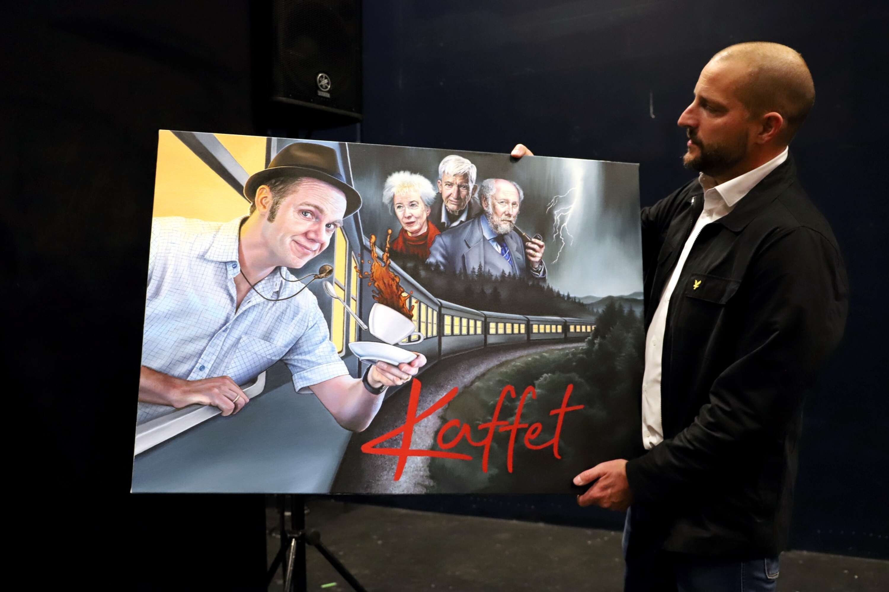 Hammarökonstnären Mathias Frykholm visar sin originalmålning, som nu blivit affisch och reklambild när föreställningen Kaffet marknadsförs över hela landet.