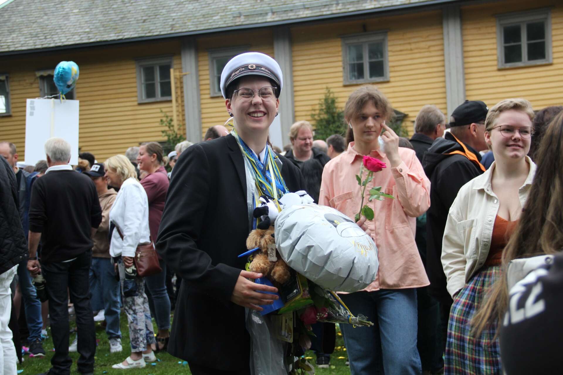 Studenterna på Herrgårdsgymnasiet springer ut och gratuleras av släkt och vänner.