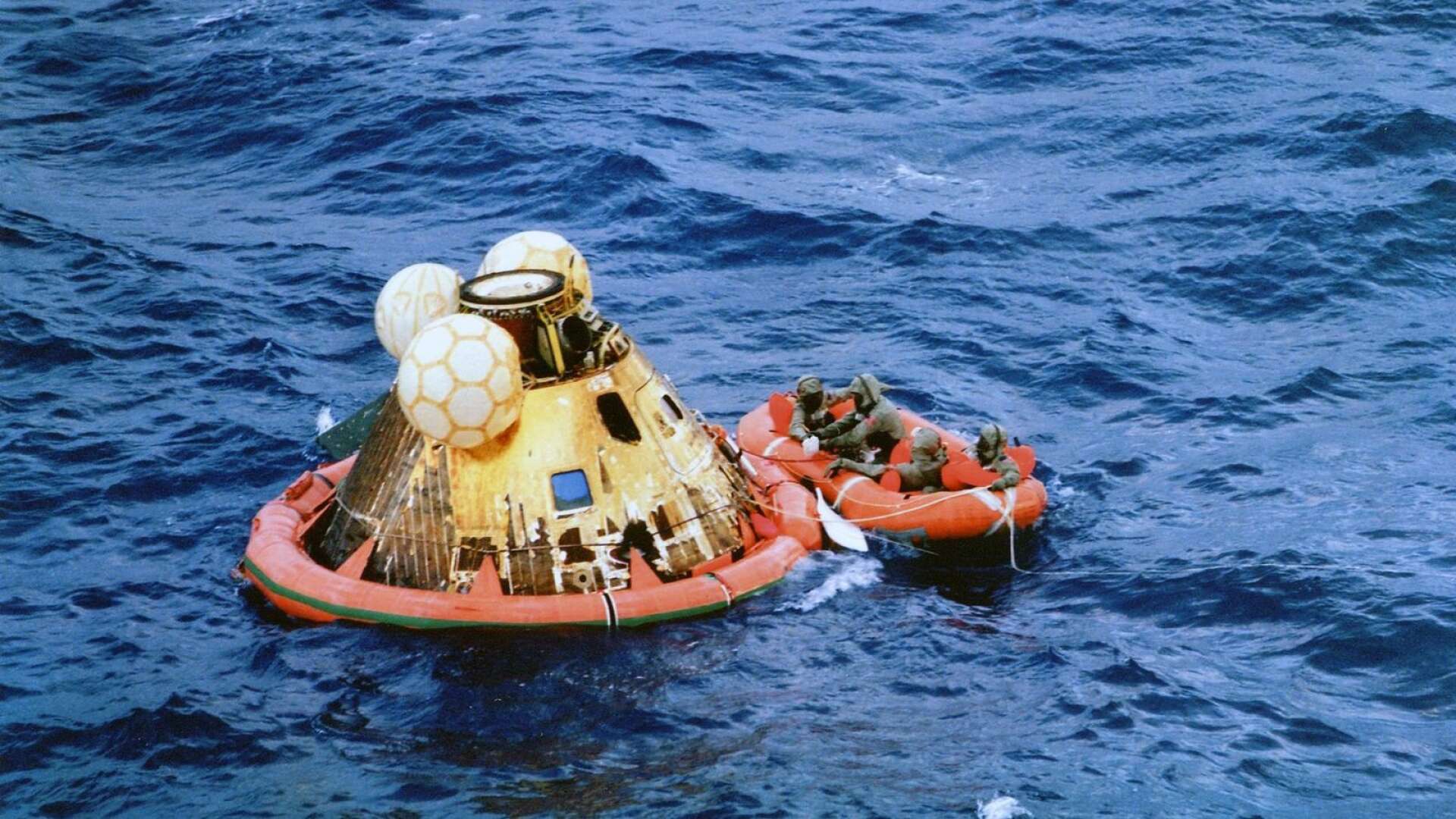 Apollo 11:s rymdkapsel sedan den slagit ner i Stilla havet och tas omhand av ytbärgare från US Navy.
